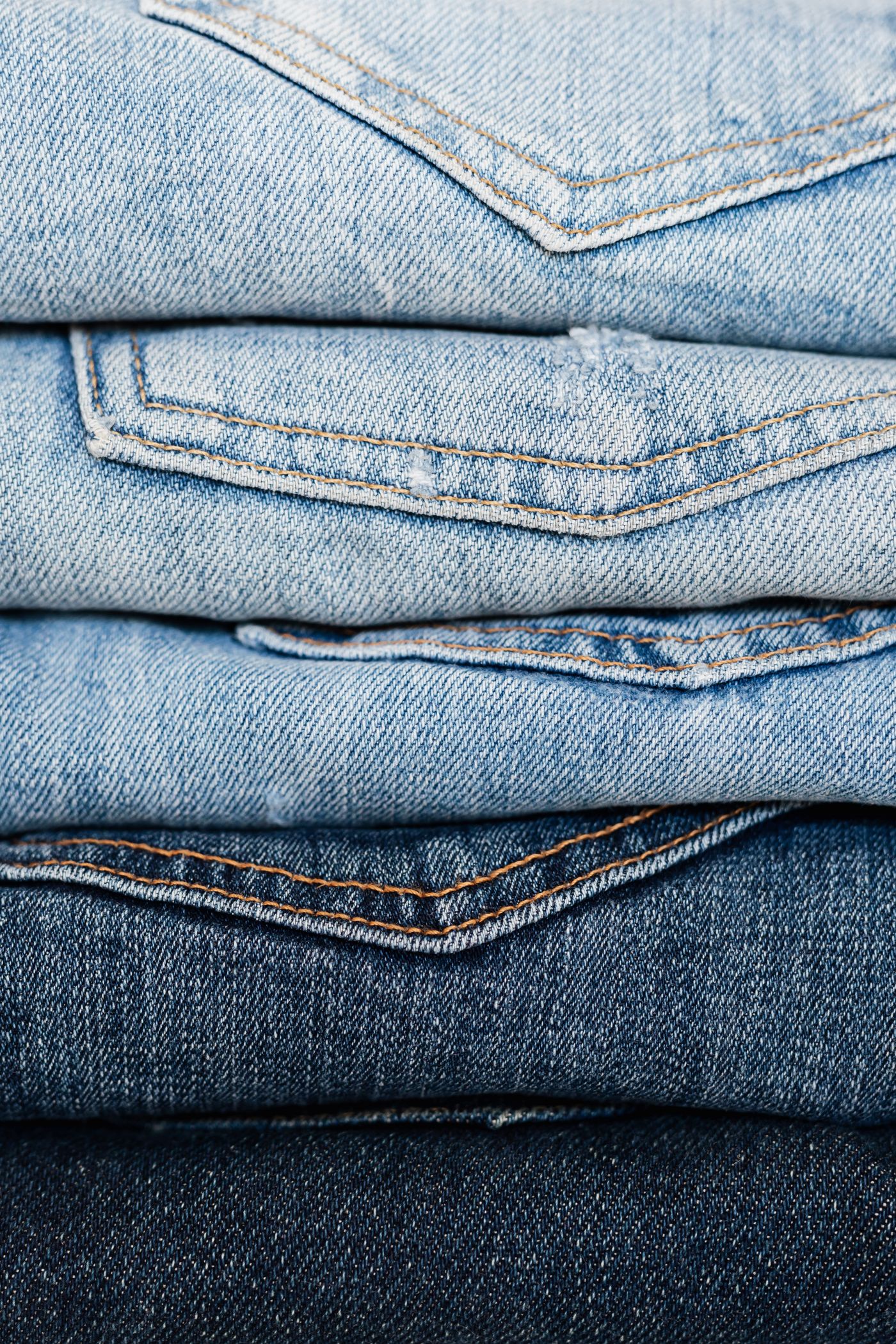 A close-up stack of folded denim showing weave and selvedge