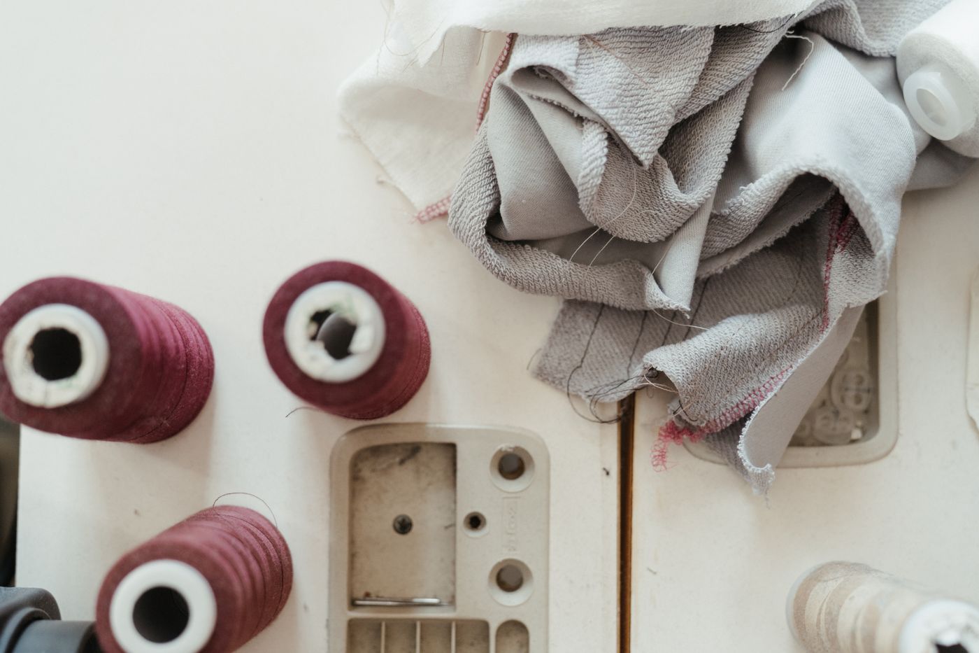 Thread spools and sewing-machine notions laid out on a worktop