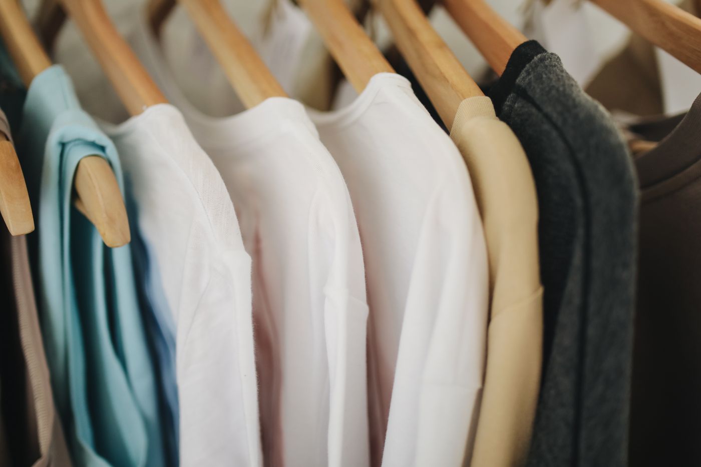 A rack of softly folded pastel garments and fabrics