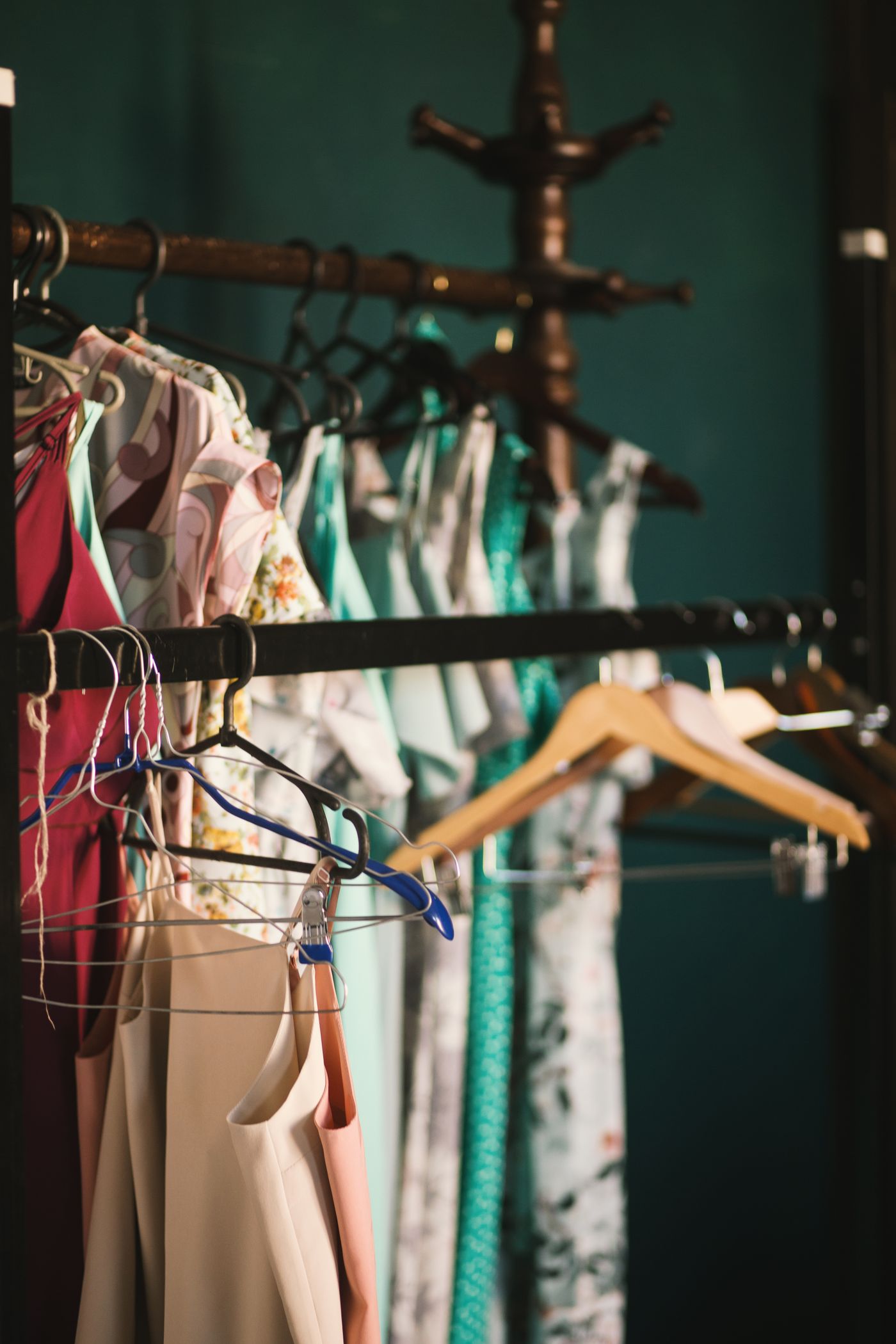 A long rack of designer fabrics and garments in warm light