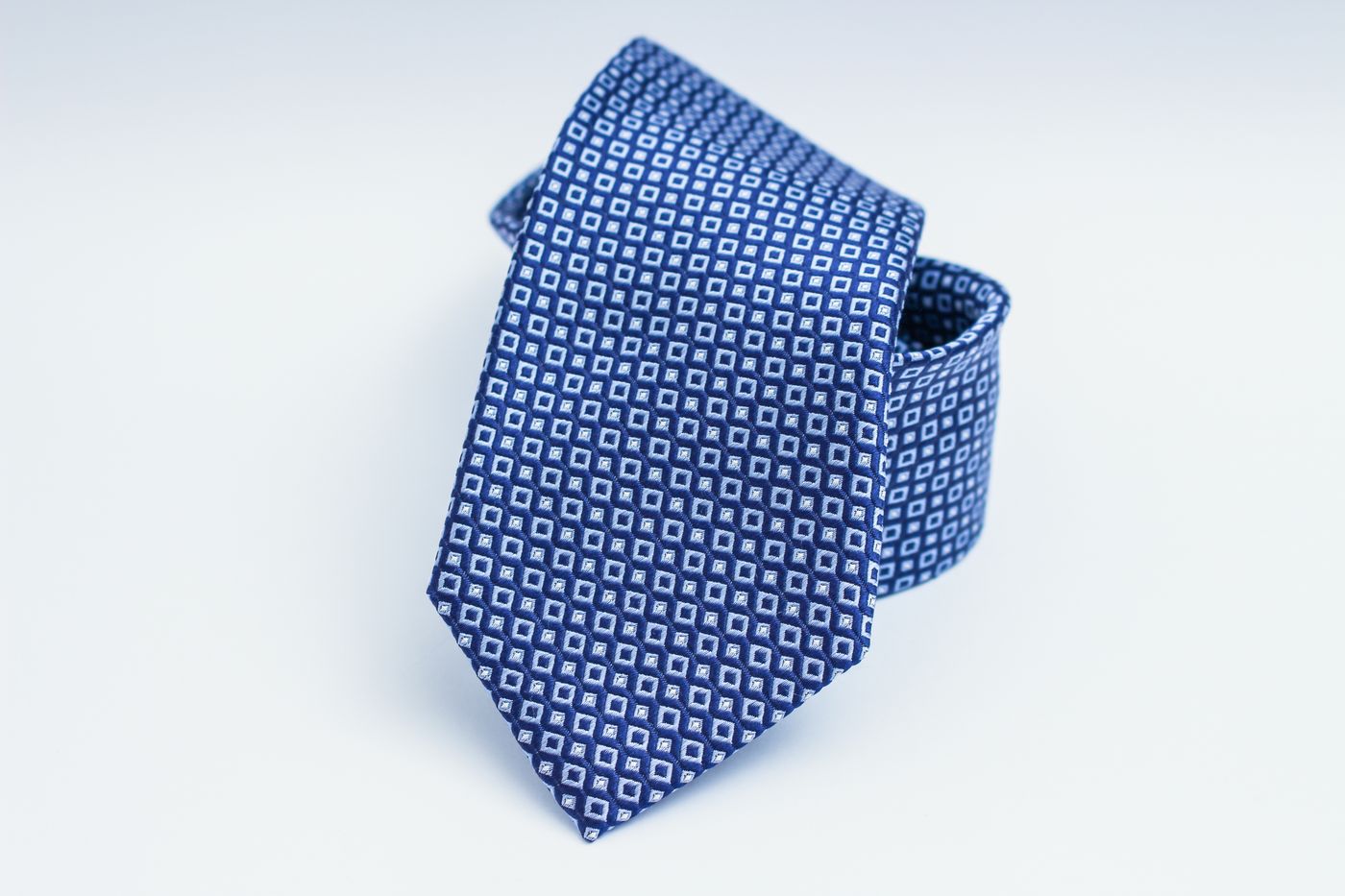 A blue patterned silk necktie showing fine woven detail