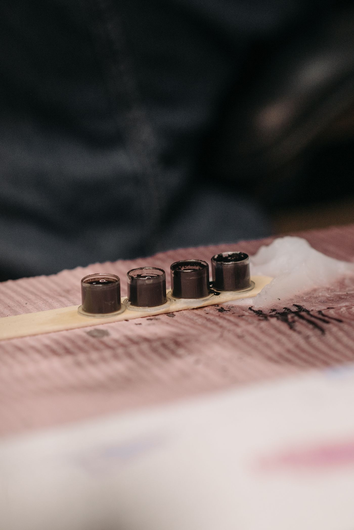 Ink cups and machine on a wooden surface