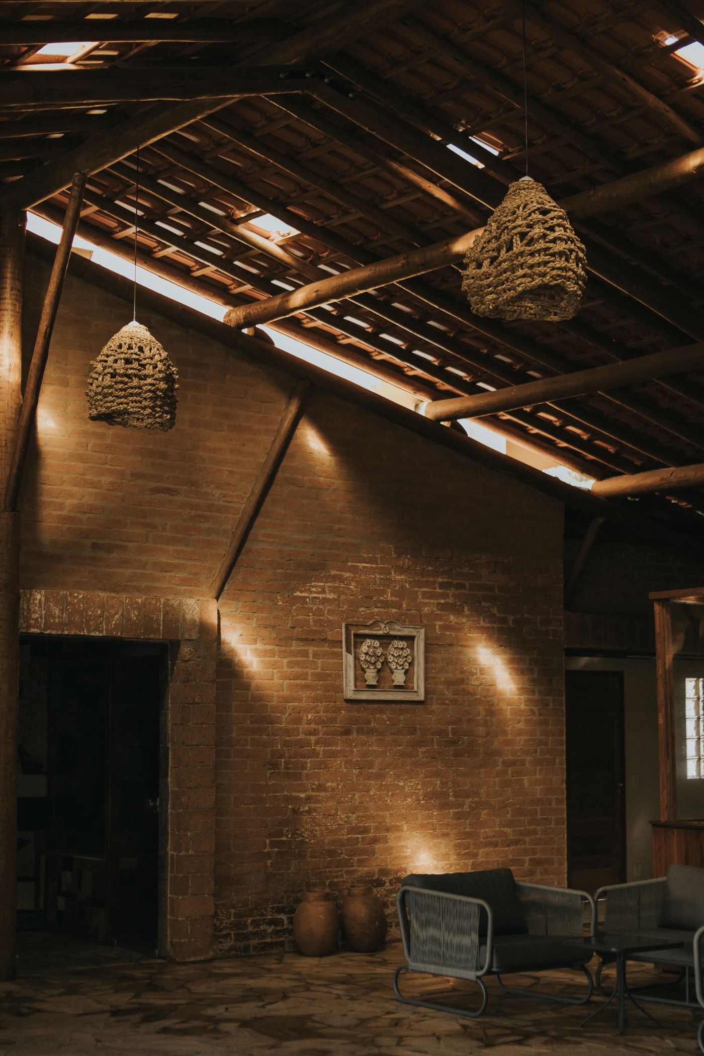 Warm brick studio interior with pendant lamps and a lounge
