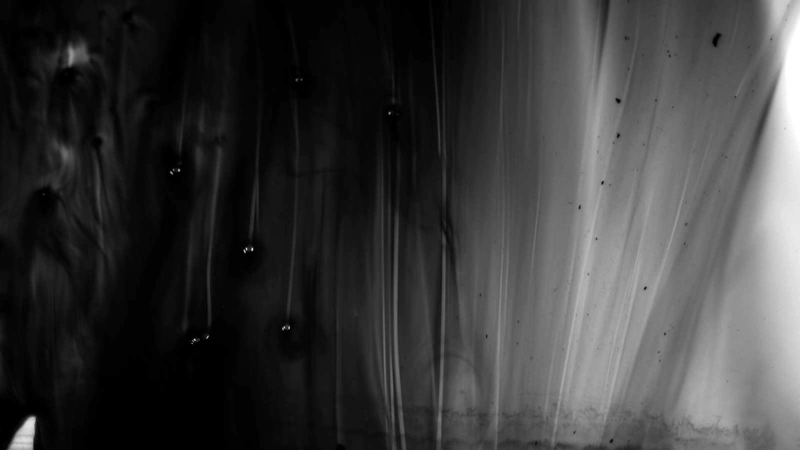 Black ink flowing through dark water