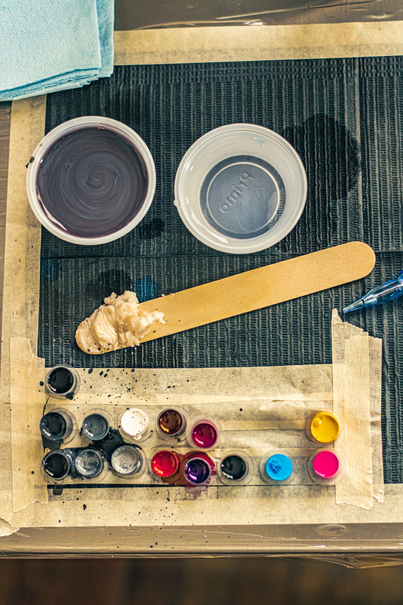 Top-down view of ink caps and pigment on a workstation mat