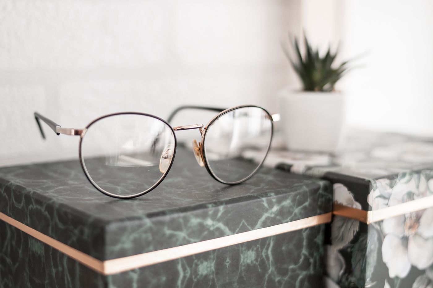 Round wire prescription frames on green marble