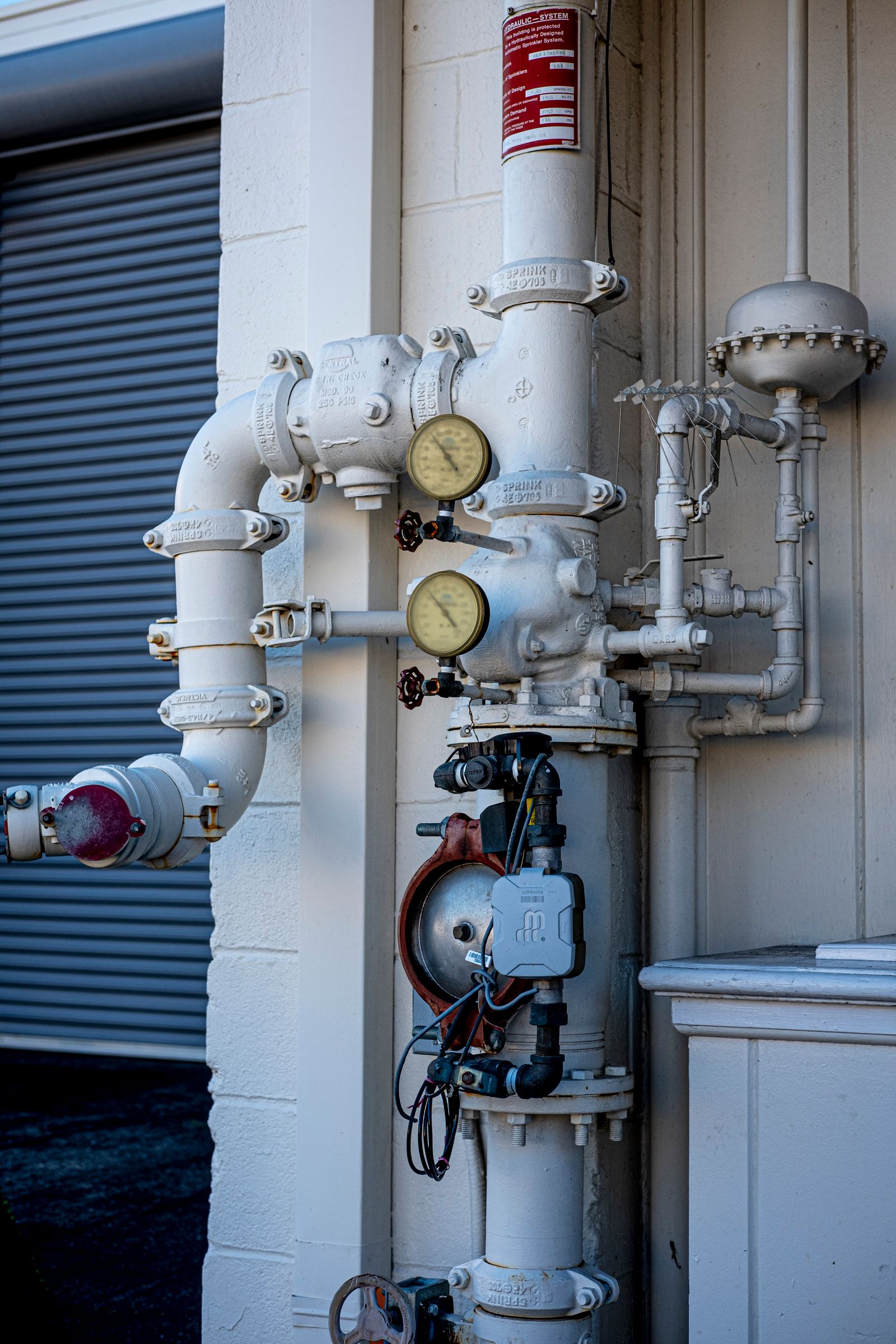 A mechanical room manifold with valves and a gauge