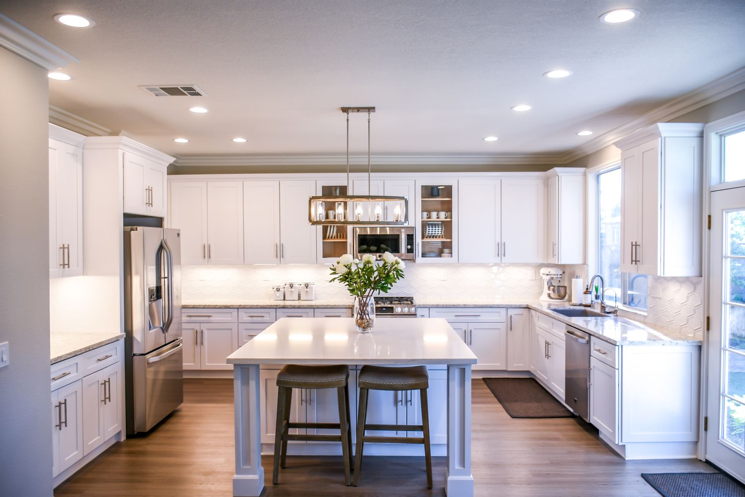 A renovated kitchen with a large island, pendant lighting and full cabinetry