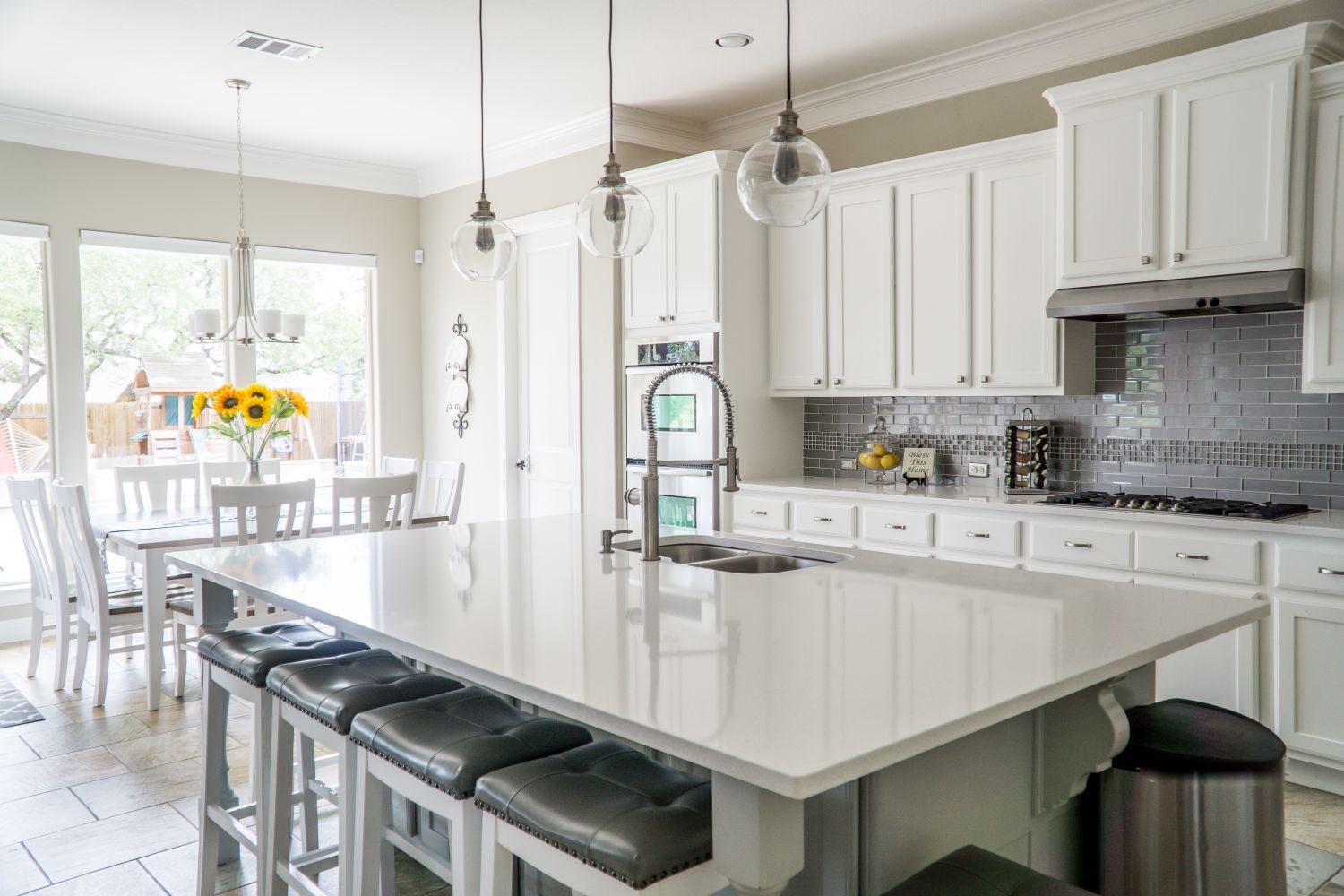 Renovated kitchen with marble island and pendant lights