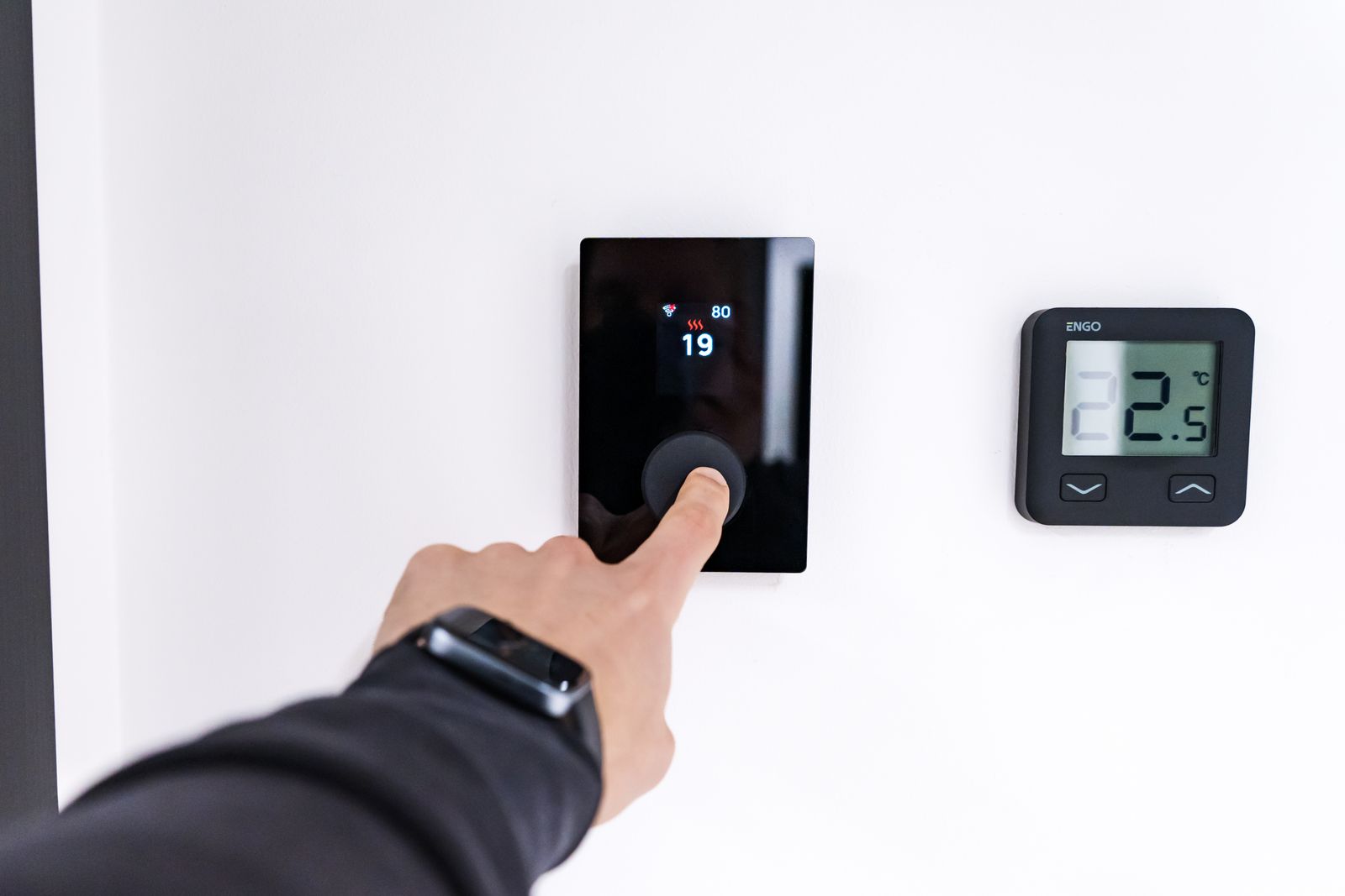 Hand adjusting a thermostat