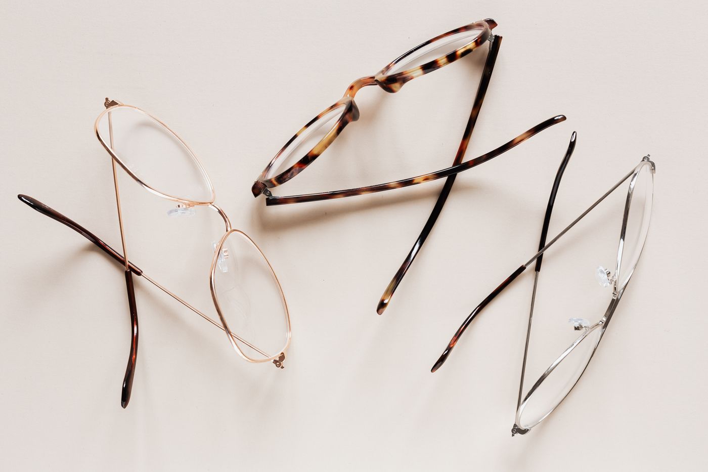 Two pairs of eyeglasses on a light surface, no face