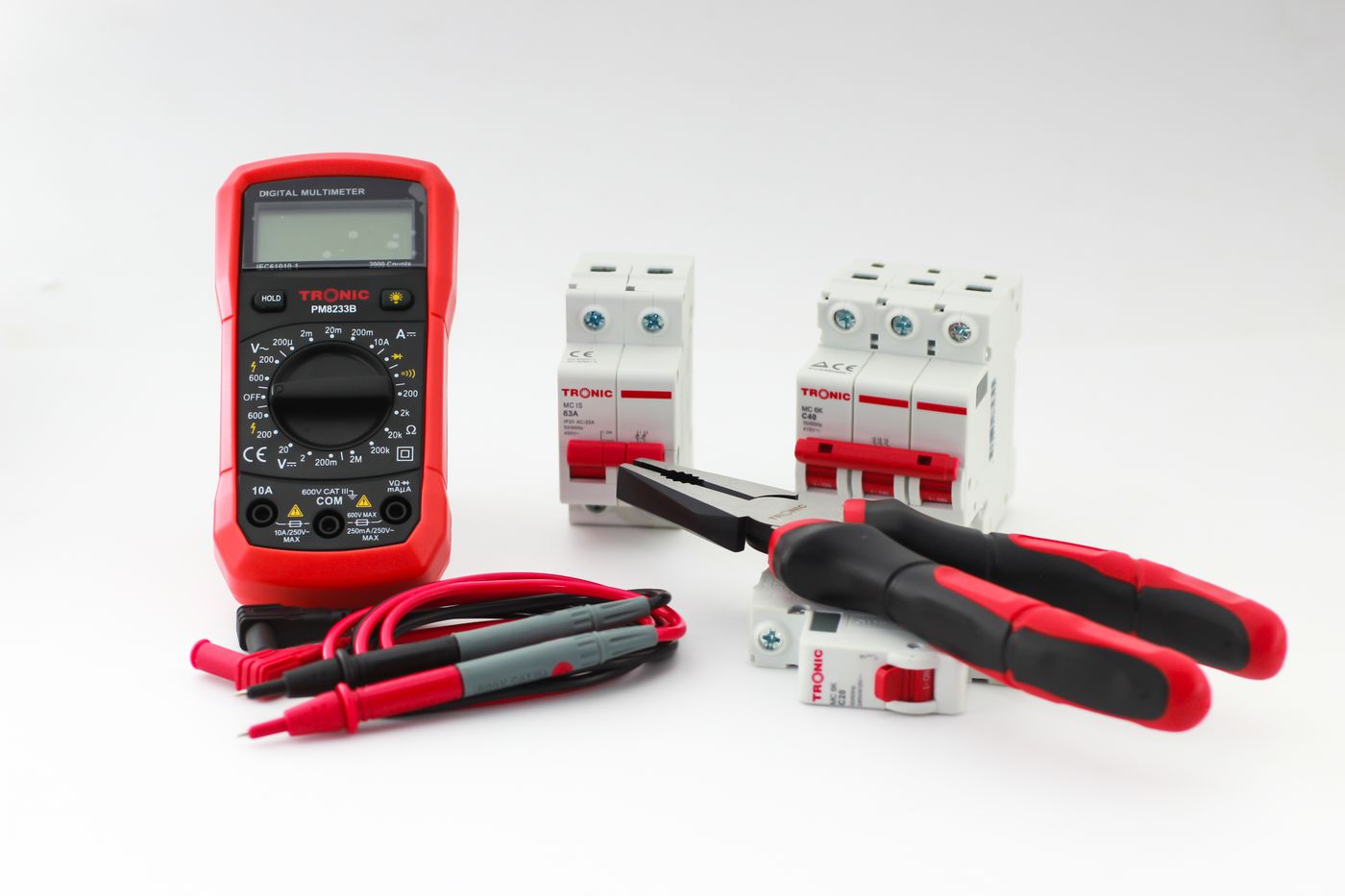 A multimeter and hand tools on a work surface