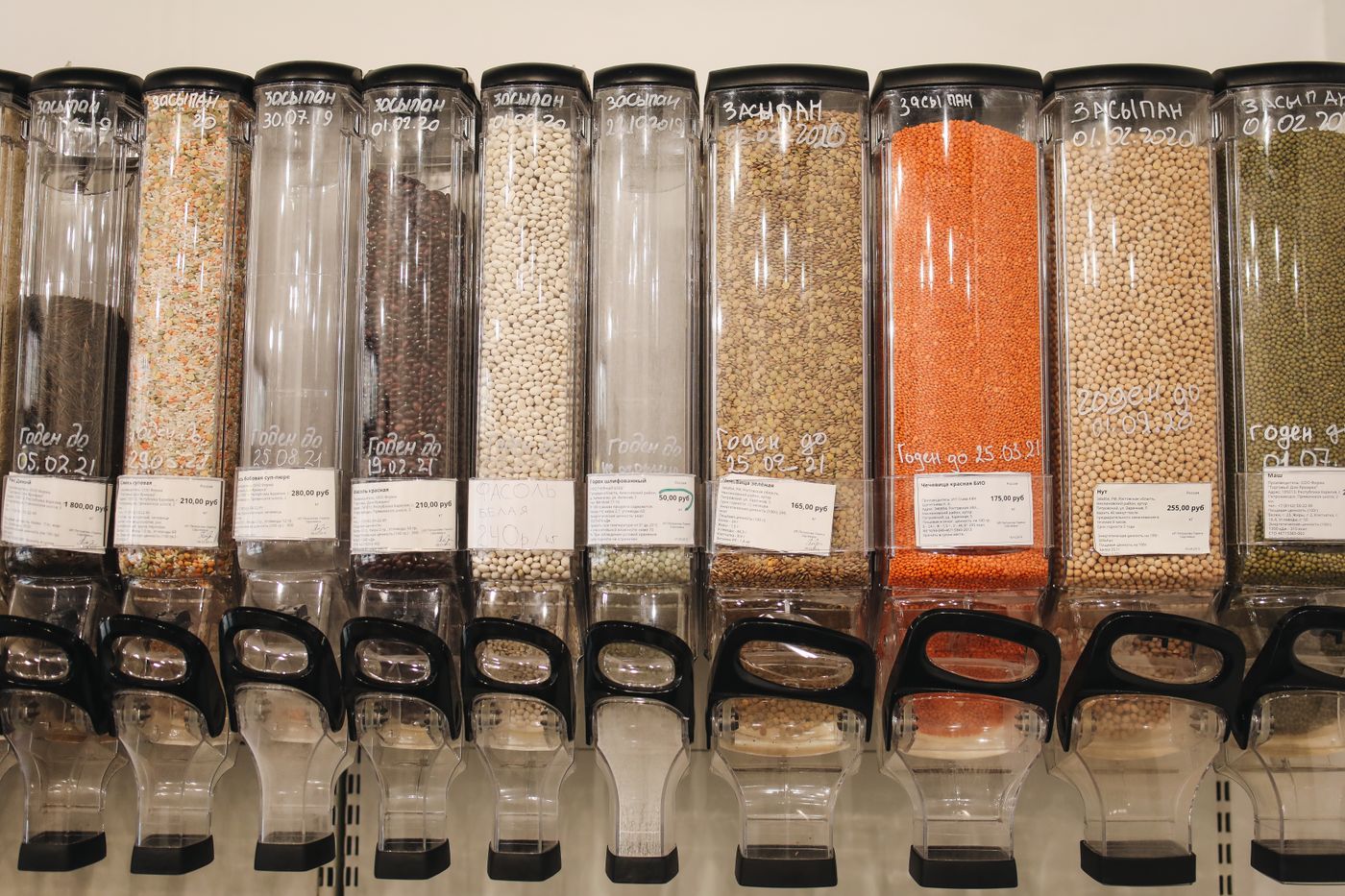 A row of gravity bulk dispensers full of grains and lentils