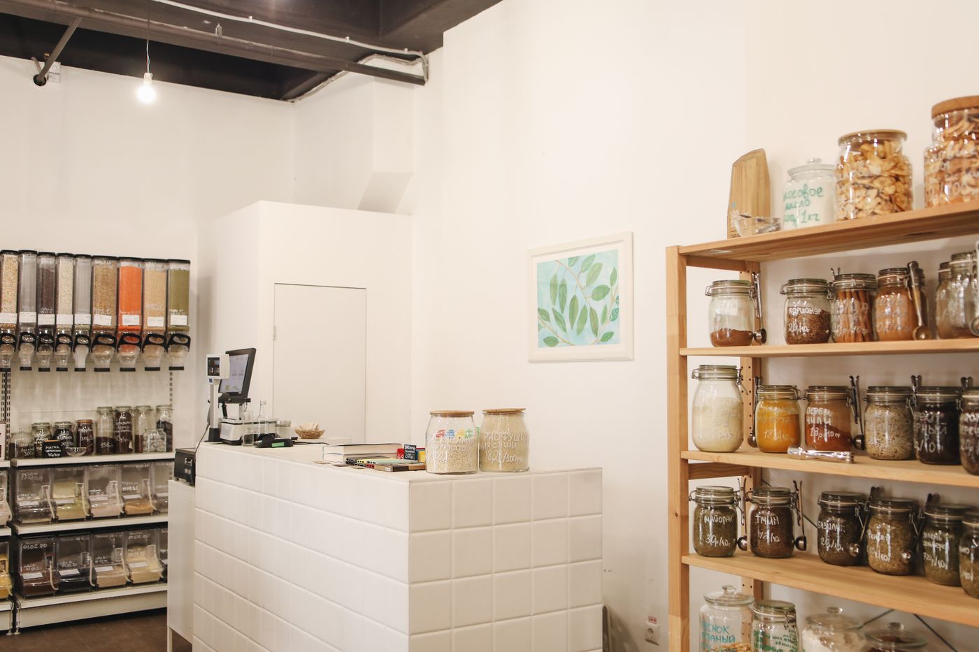 The interior of a natural-grocery shop with jars and bulk dispensers on wooden shelves