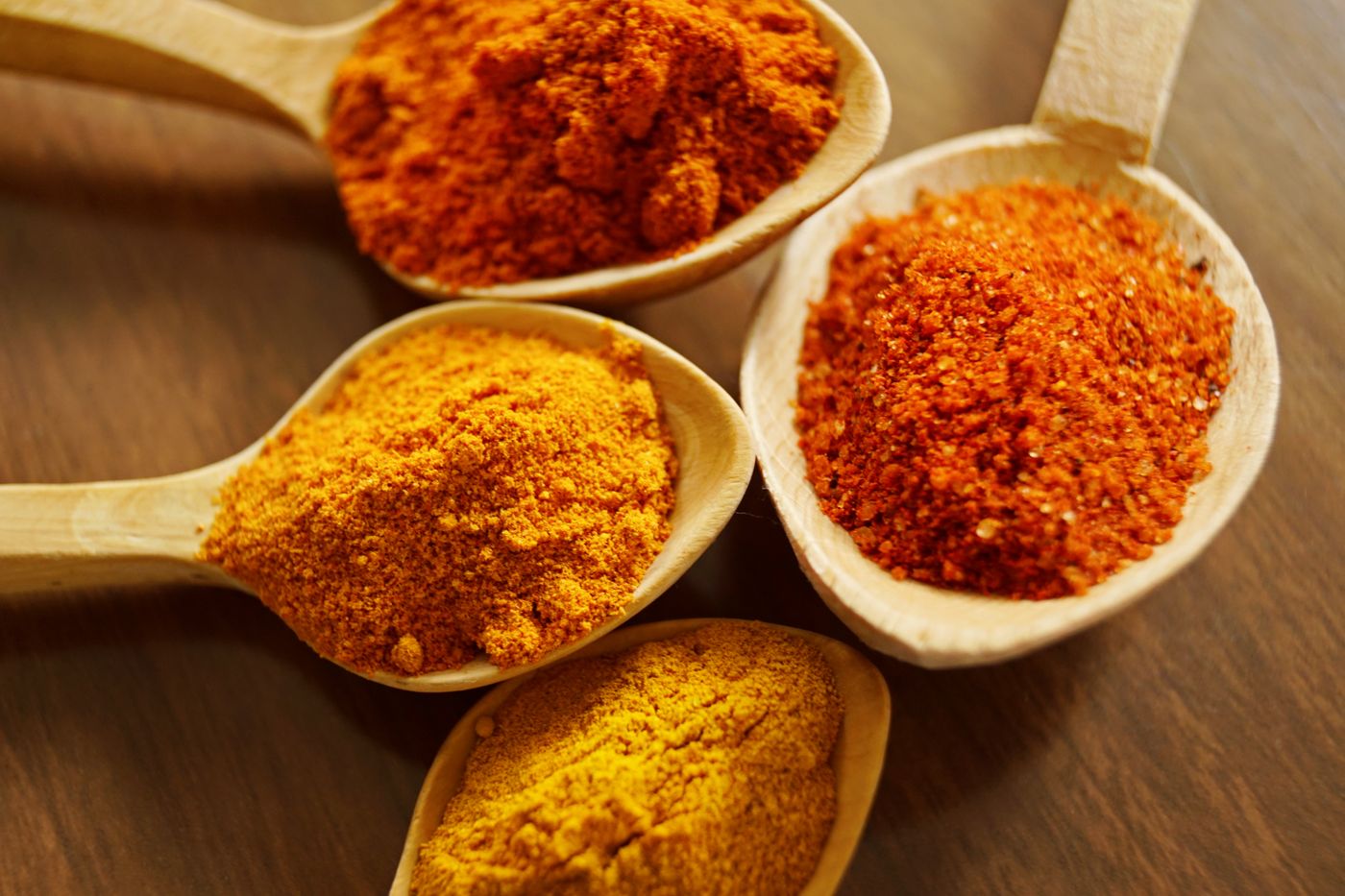Wooden scoops of turmeric and paprika