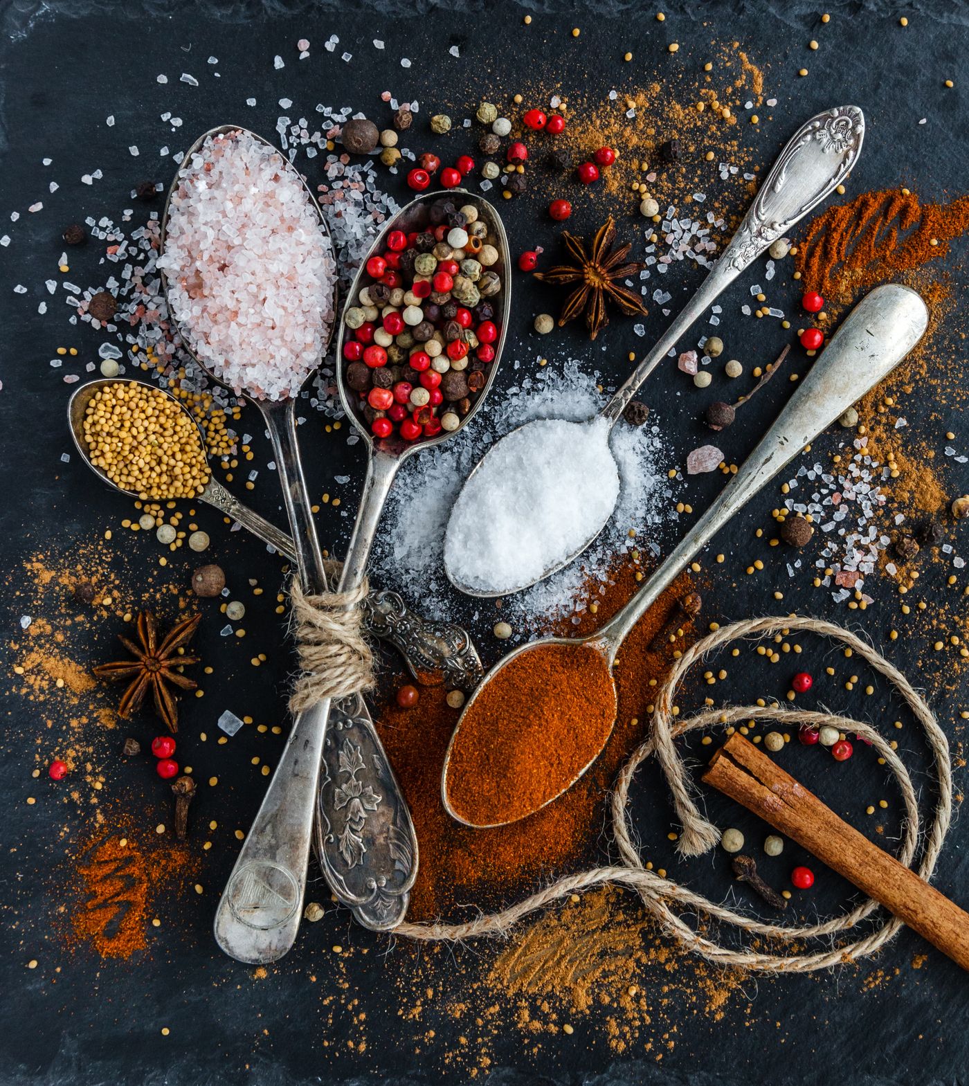 Spices and spoons on a dark surface