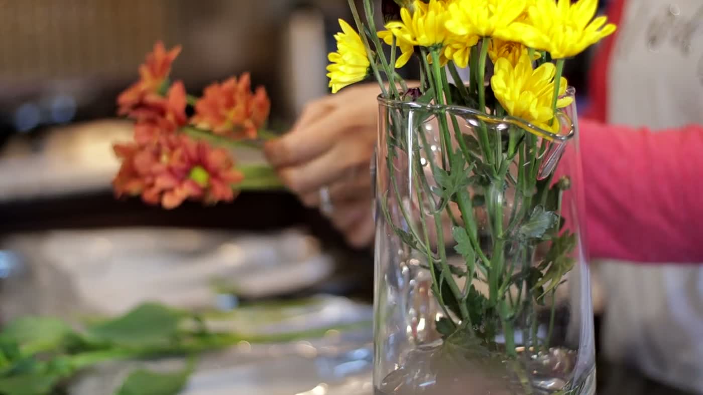 Hands arranging fresh flowers on a florist's bench