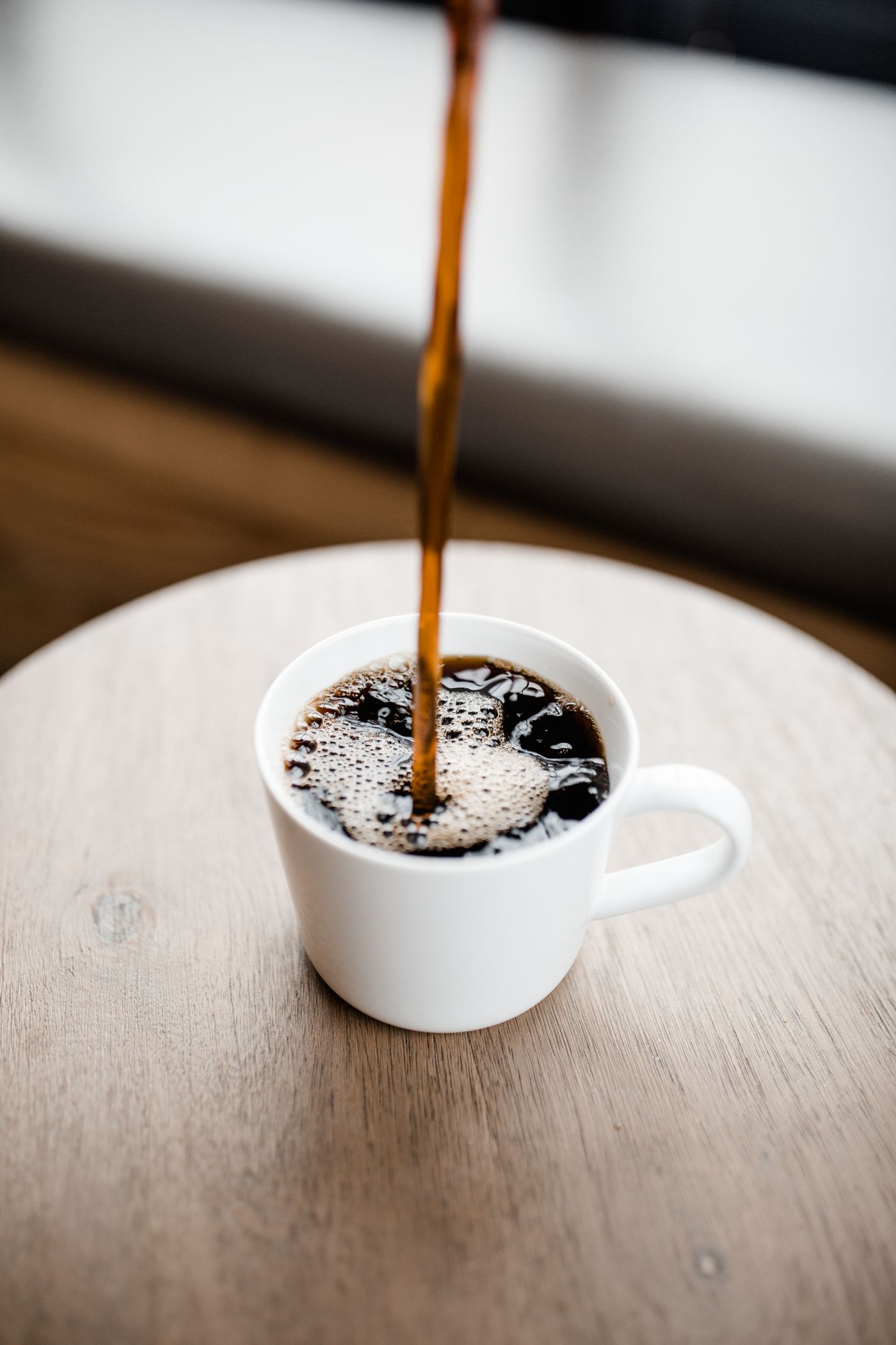 Coffee being poured from a brewer into a cup