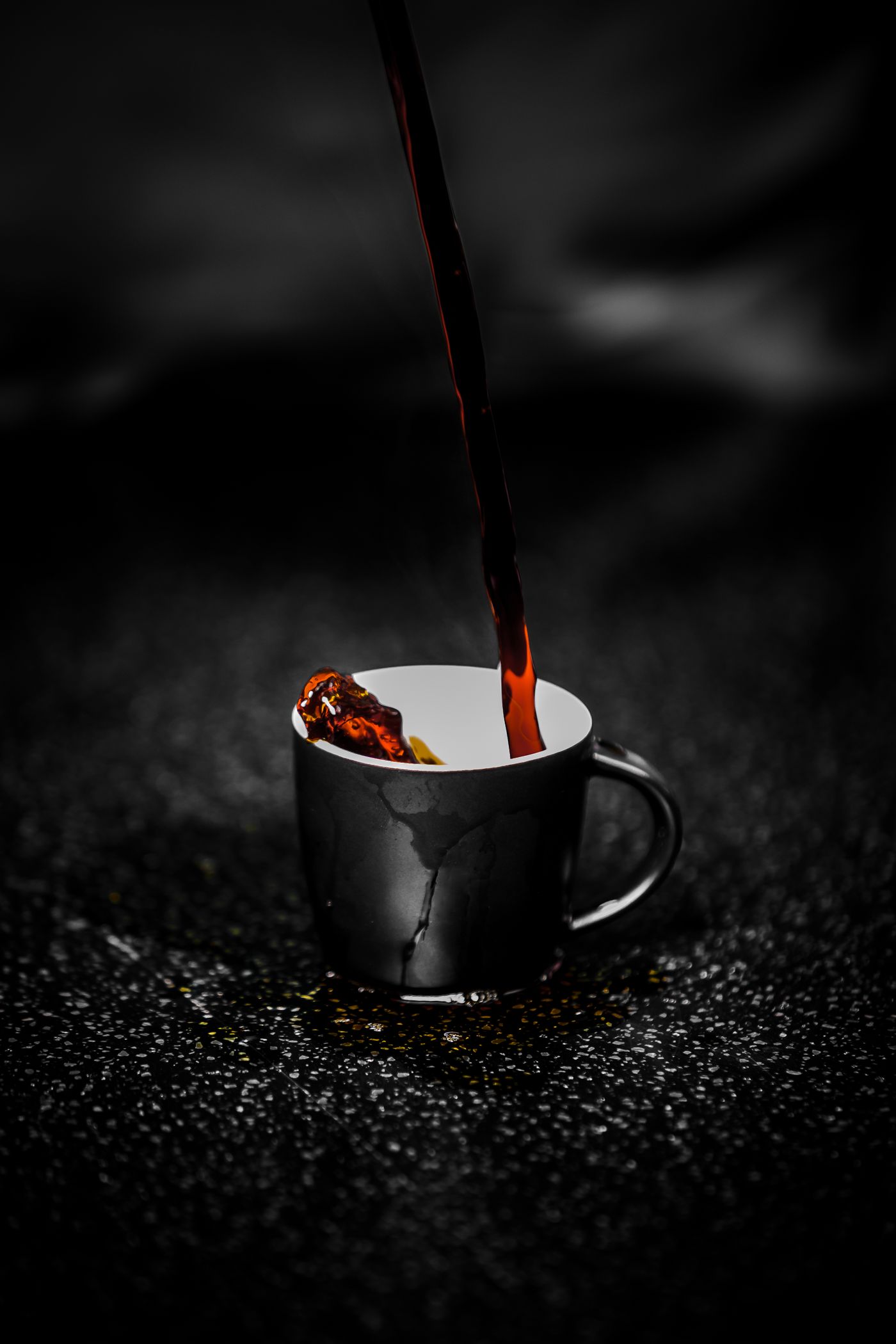A dark mug of coffee being poured