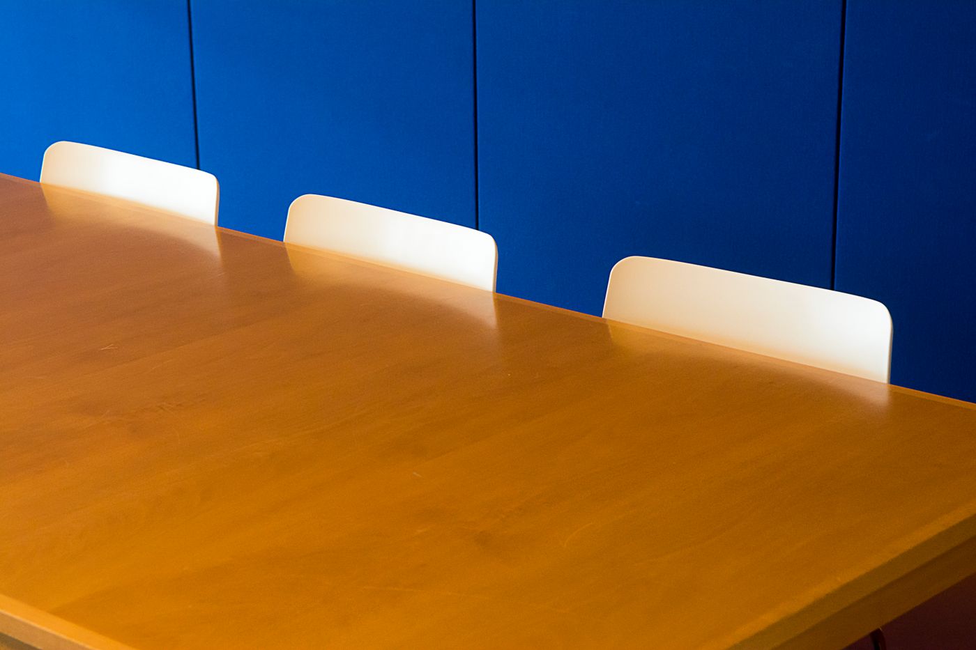 A warm wooden meeting table in a consultation room