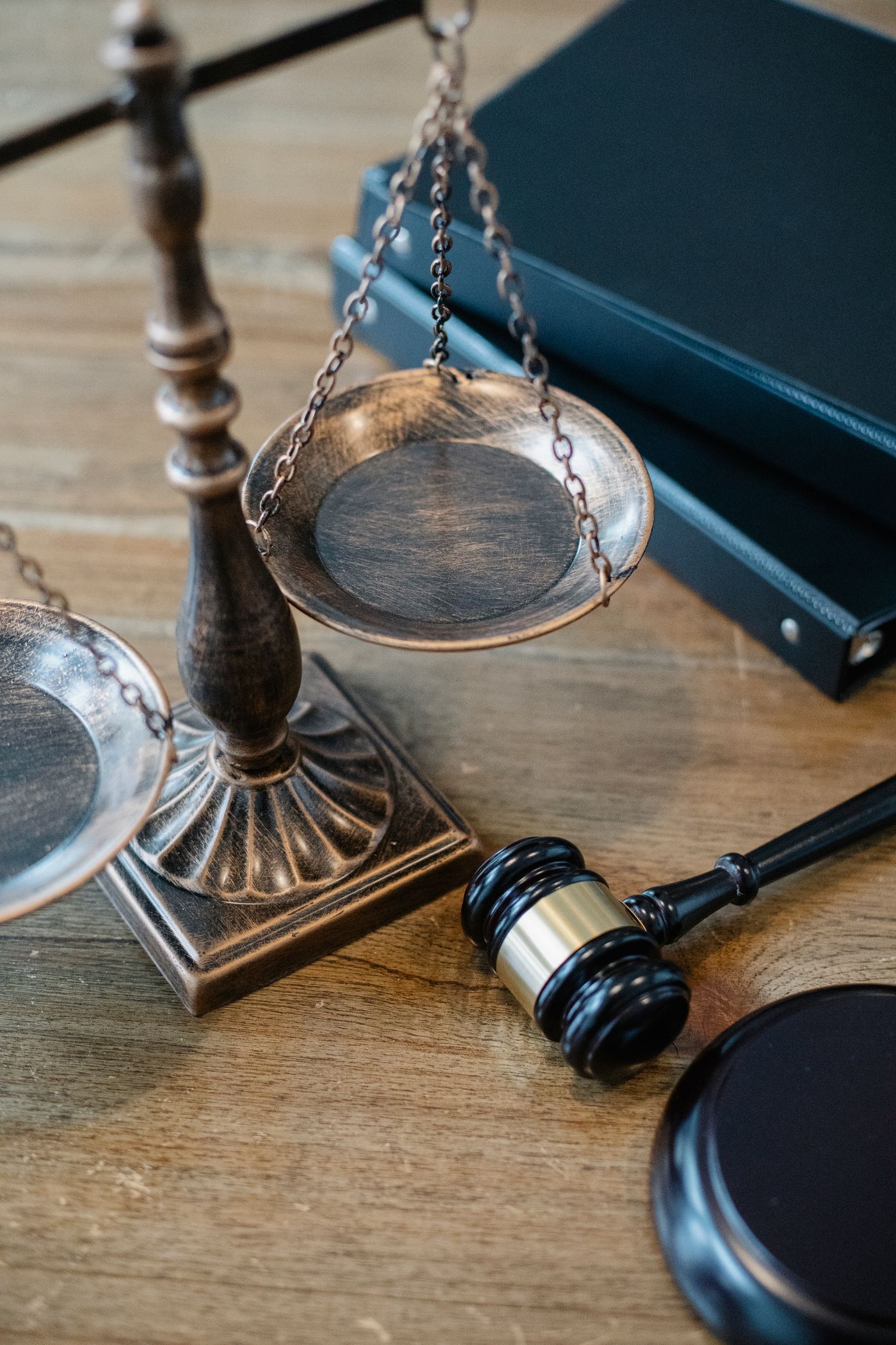 Brass scales of justice and a gavel resting beside law books on a desk