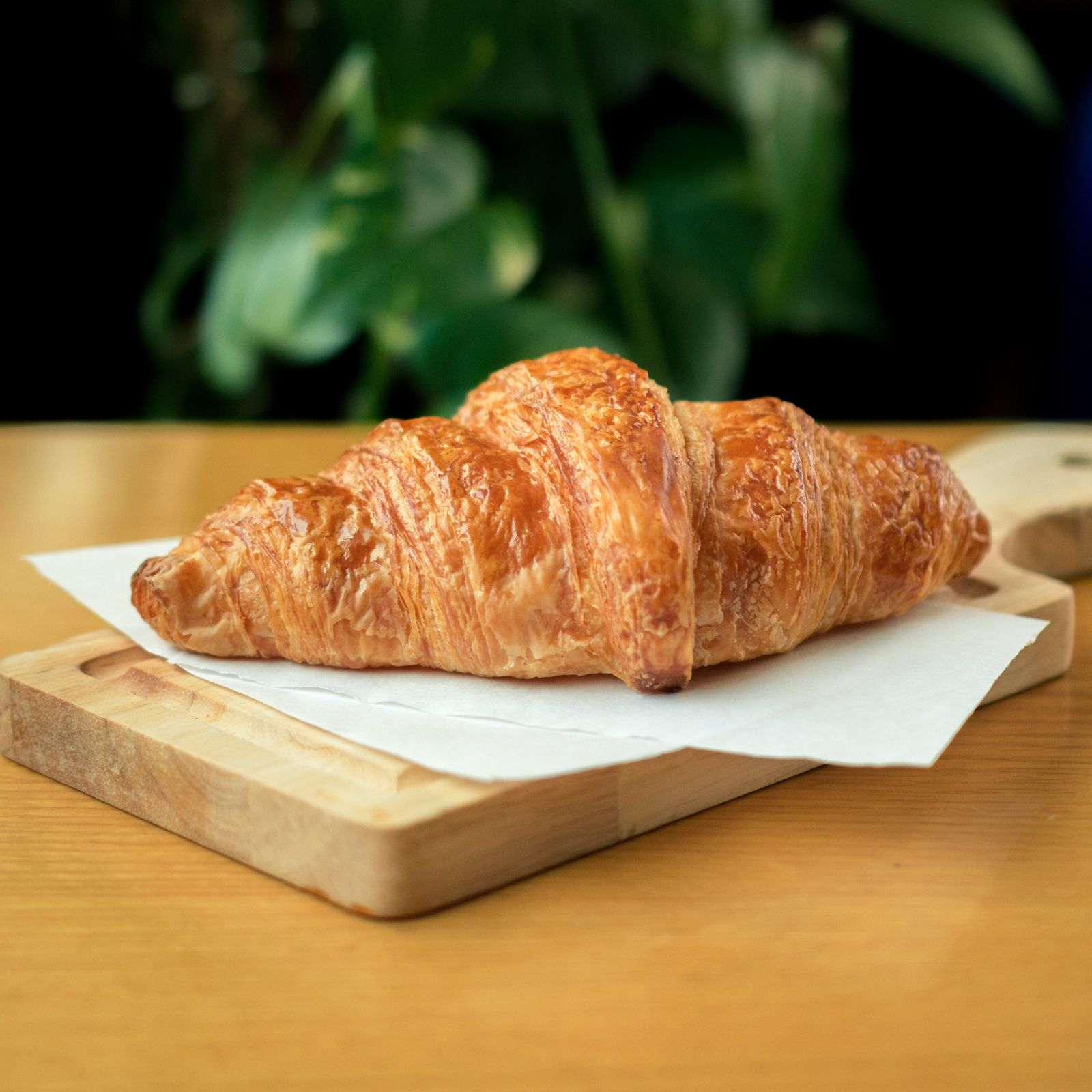 A golden croissant on a board