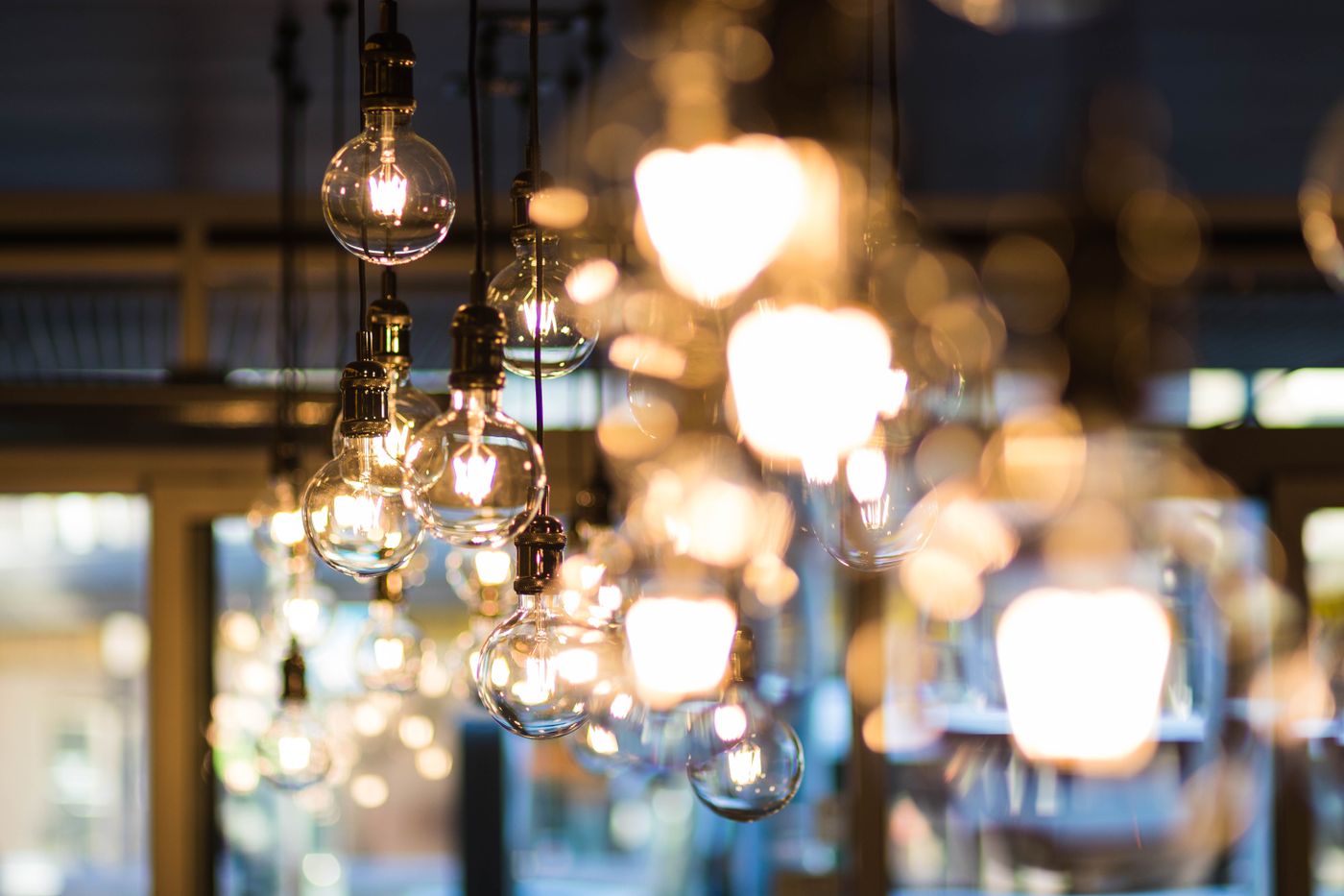 A cluster of warm Edison-bulb pendant lights glowing amber