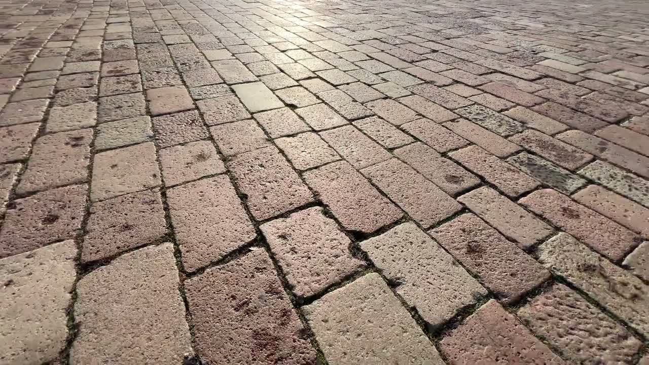 A long paver pathway receding into the distance at golden hour