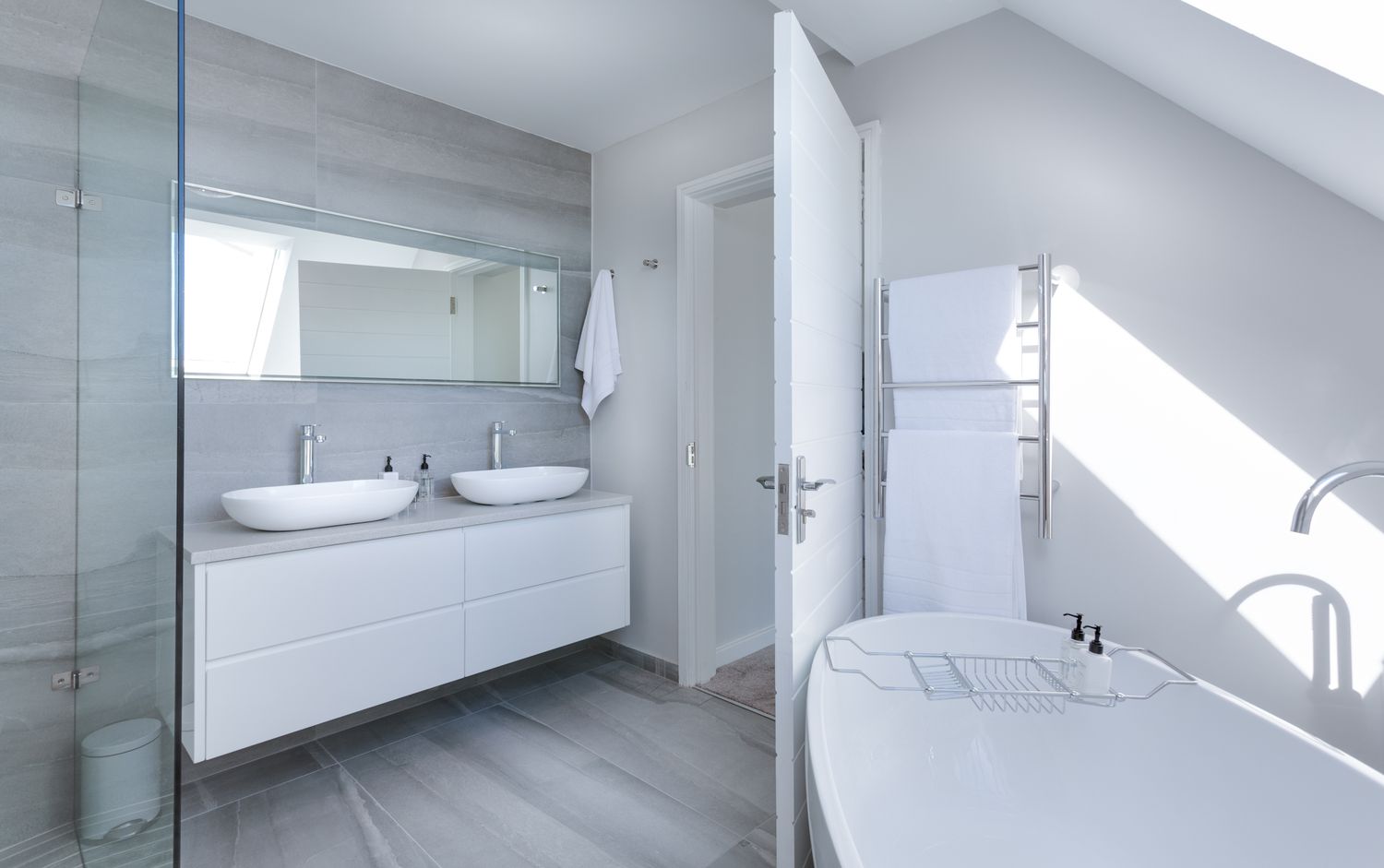 A renovated bathroom with floating vanity, mirror and large-format tile