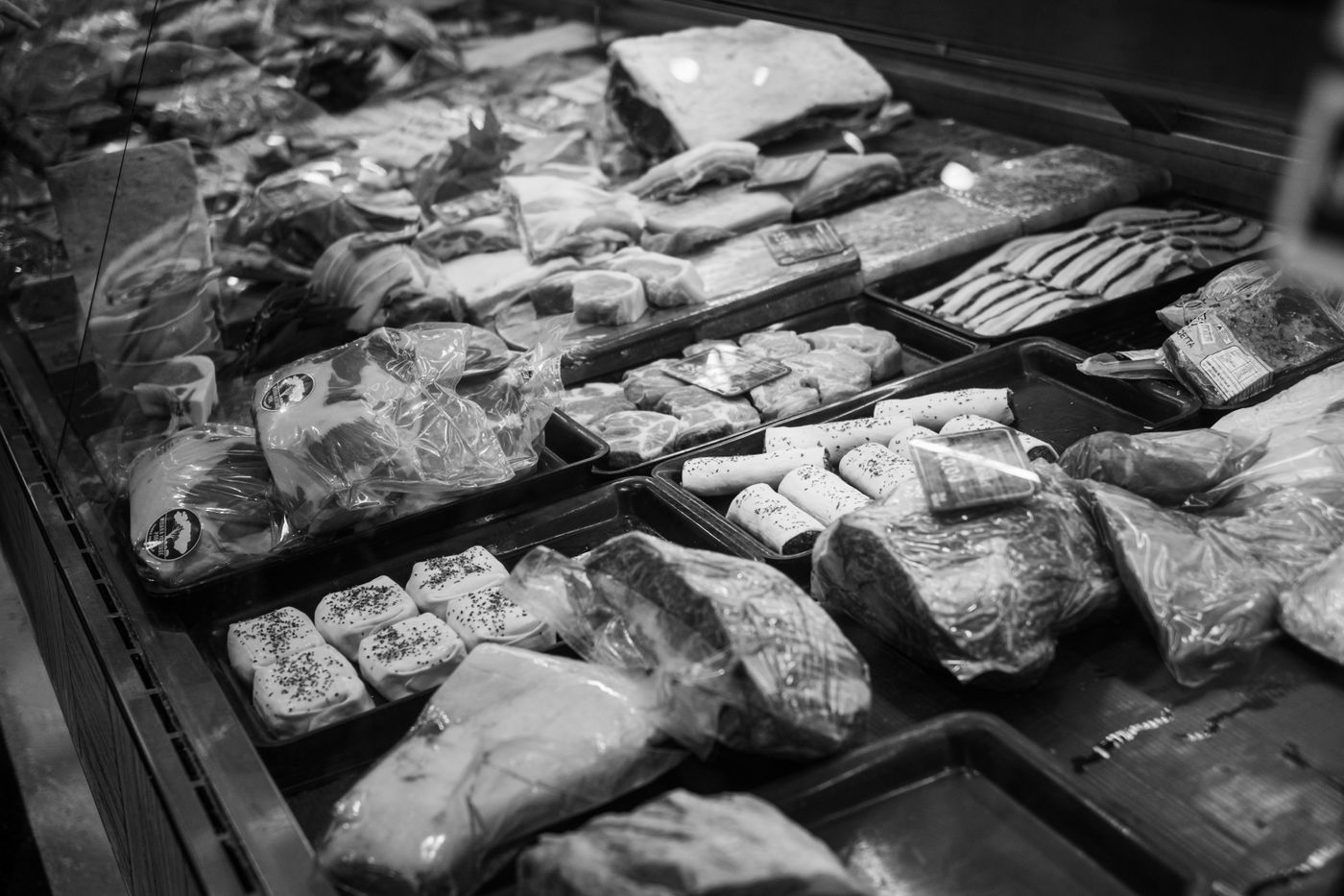 Display case of fresh cuts of meat, black and white