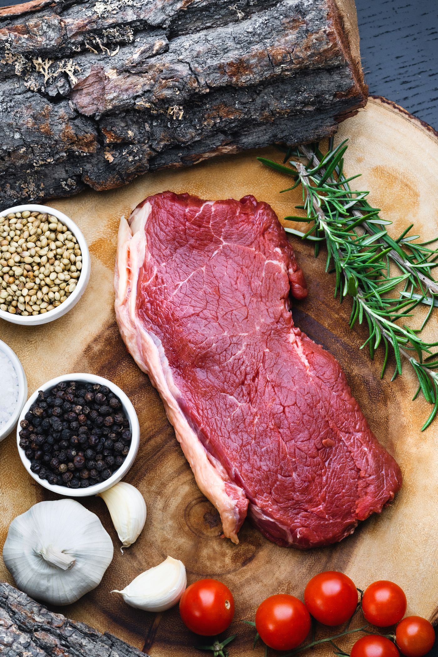 Raw steak with herbs and spices laid out