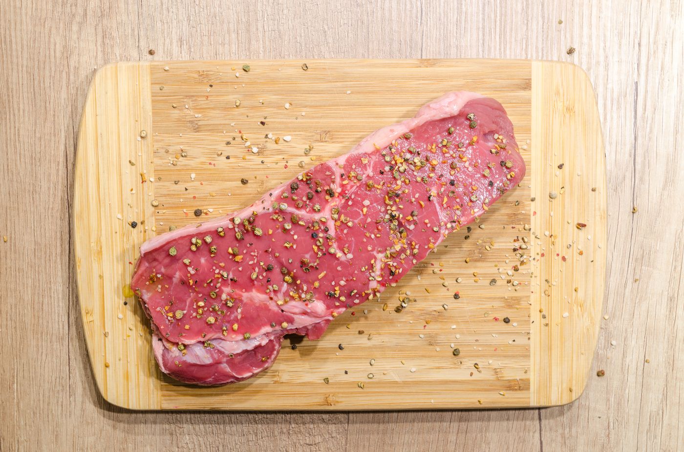 Raw steak on a board with rosemary