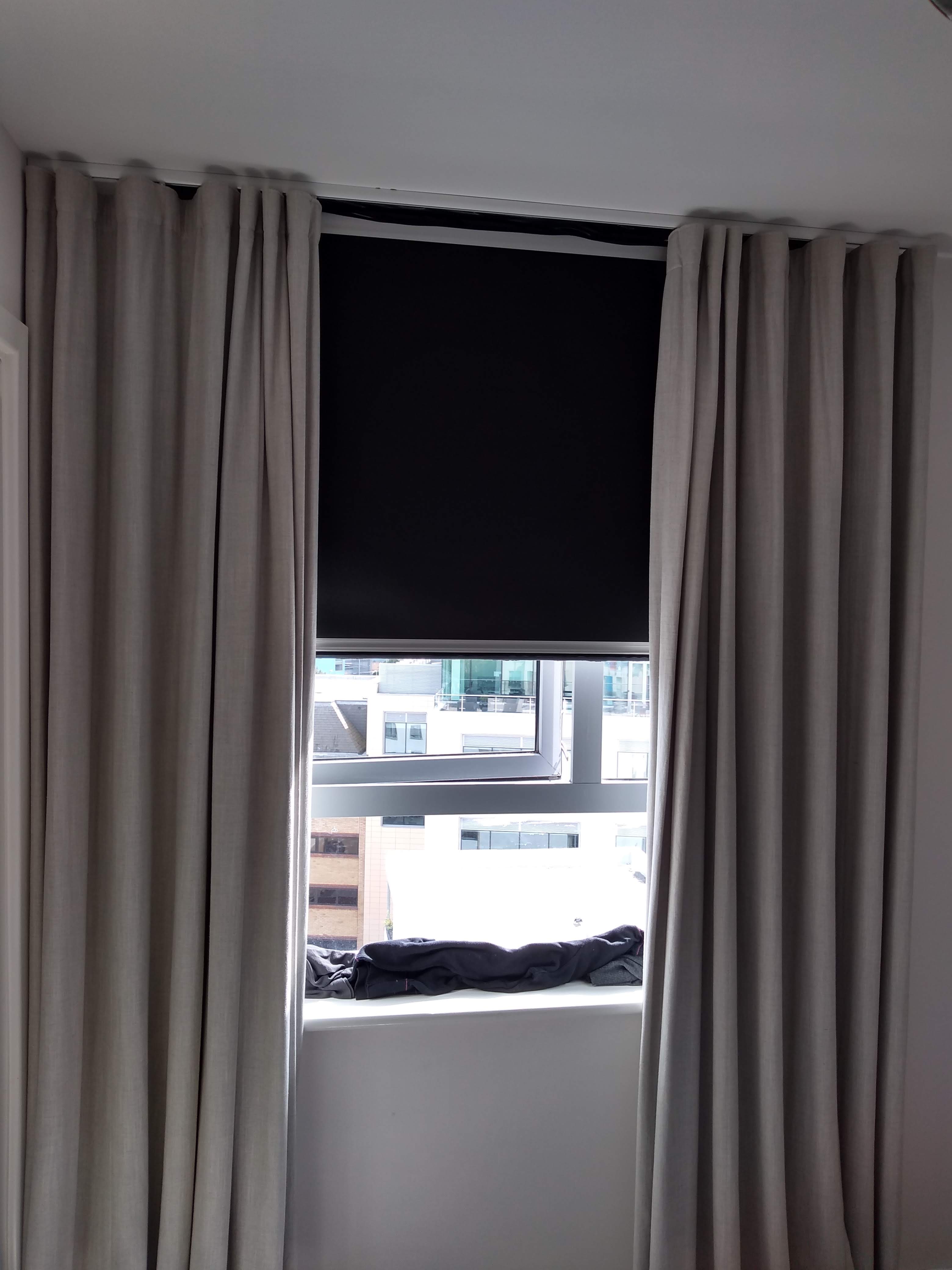 A blackout roller blind with drapery
