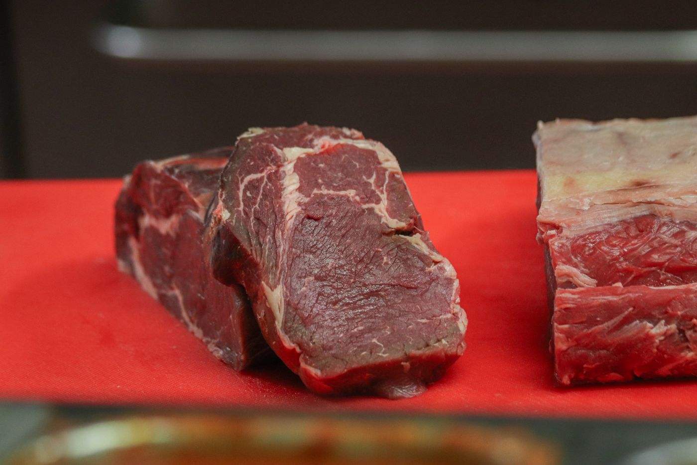 Raw marbled beef on a red cutting board