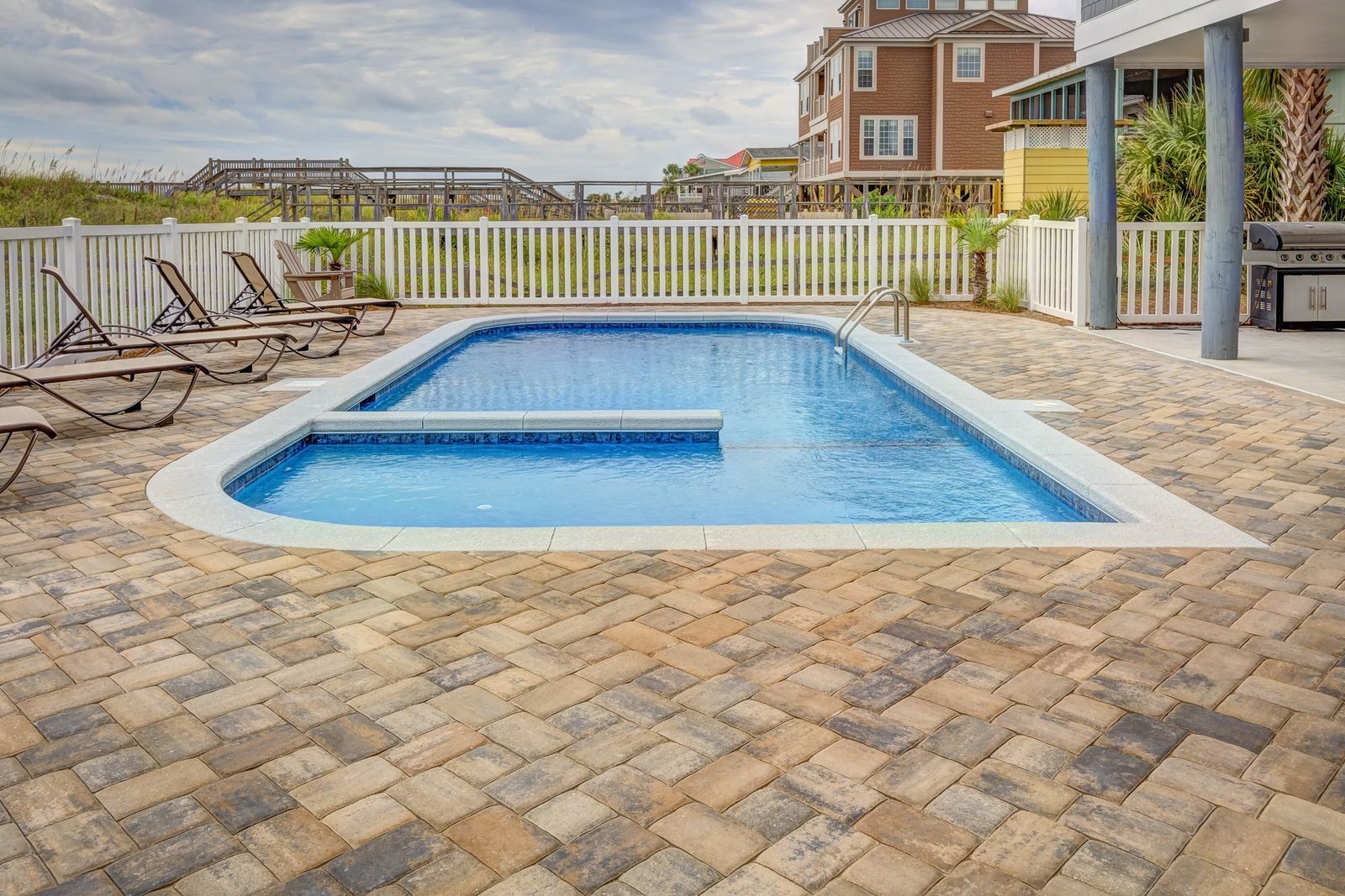 Backyard pool shell set in a paver-deck yard