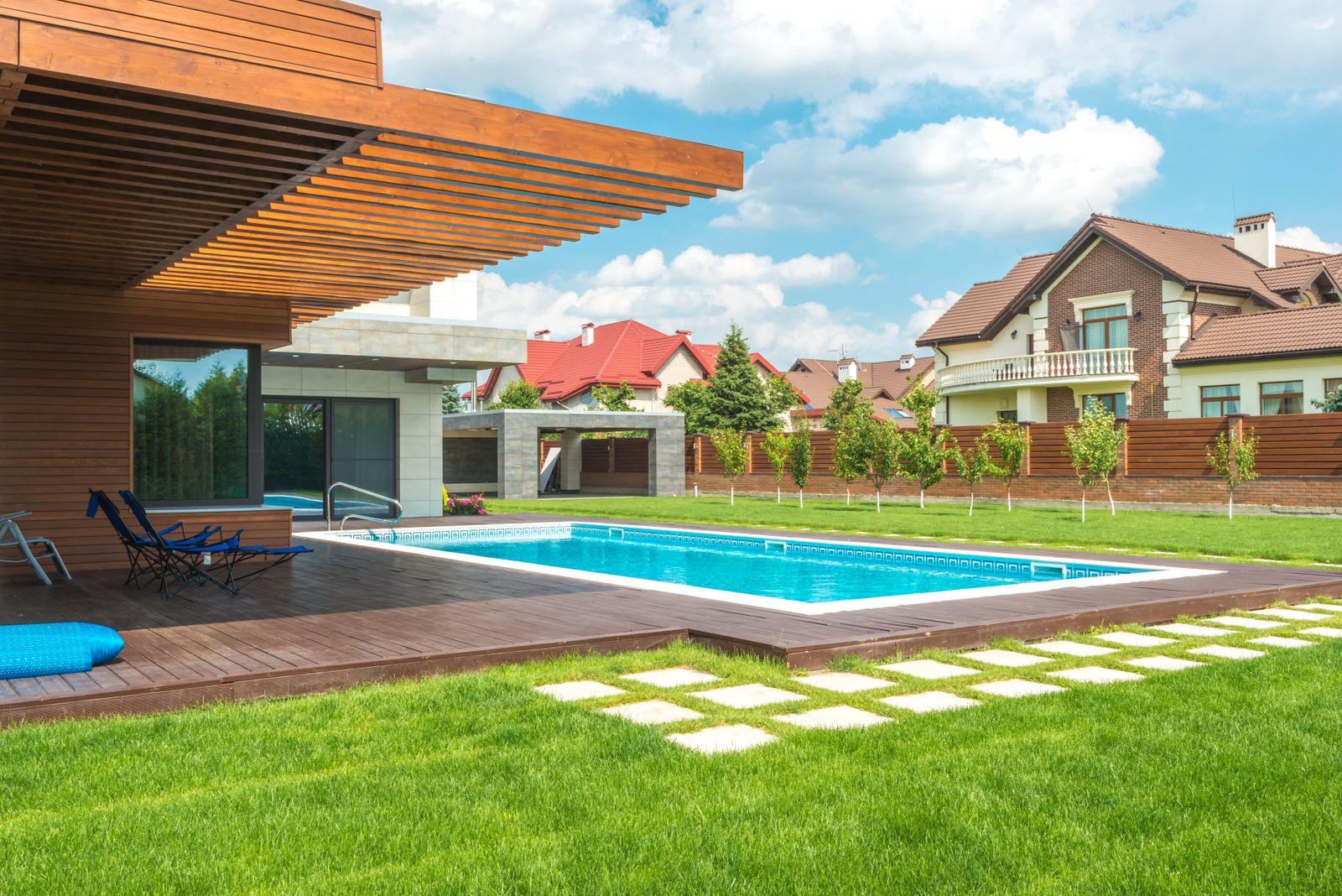 Modern backyard pool with wood deck under construction