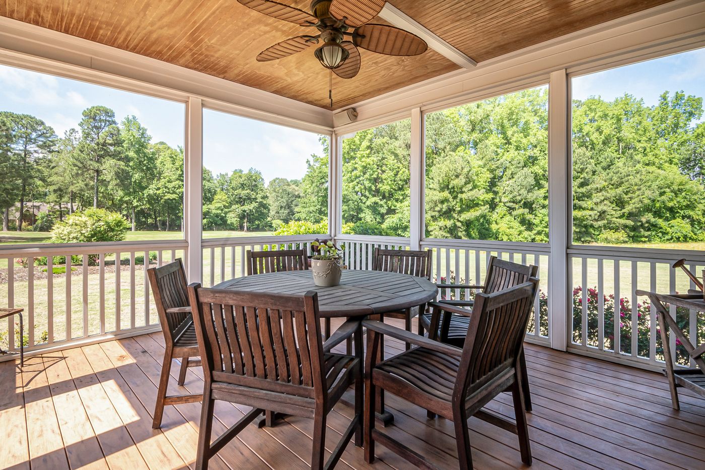 Covered porch with a wood ceiling and dining set