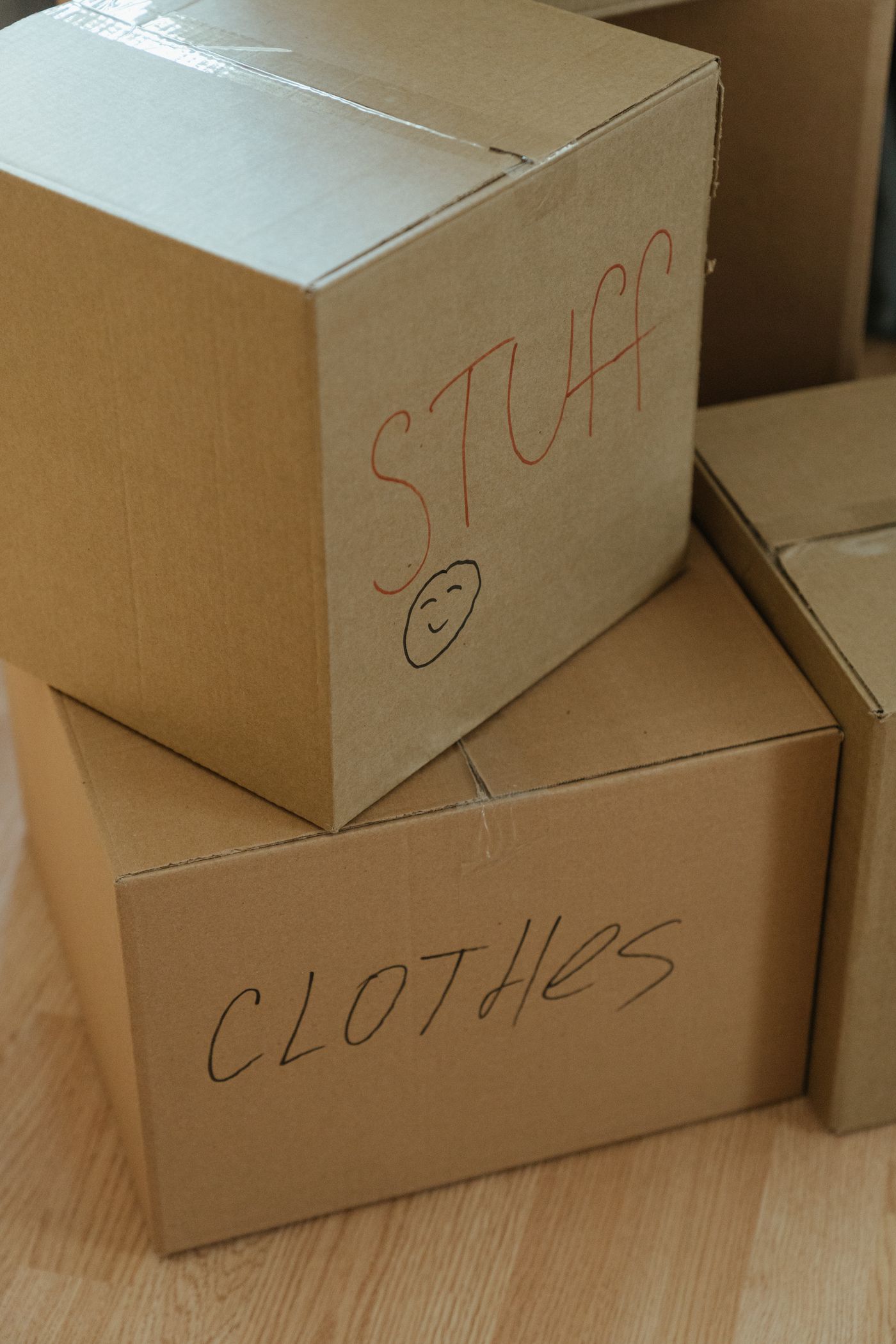 Cardboard moving boxes labelled by room, stacked and ready