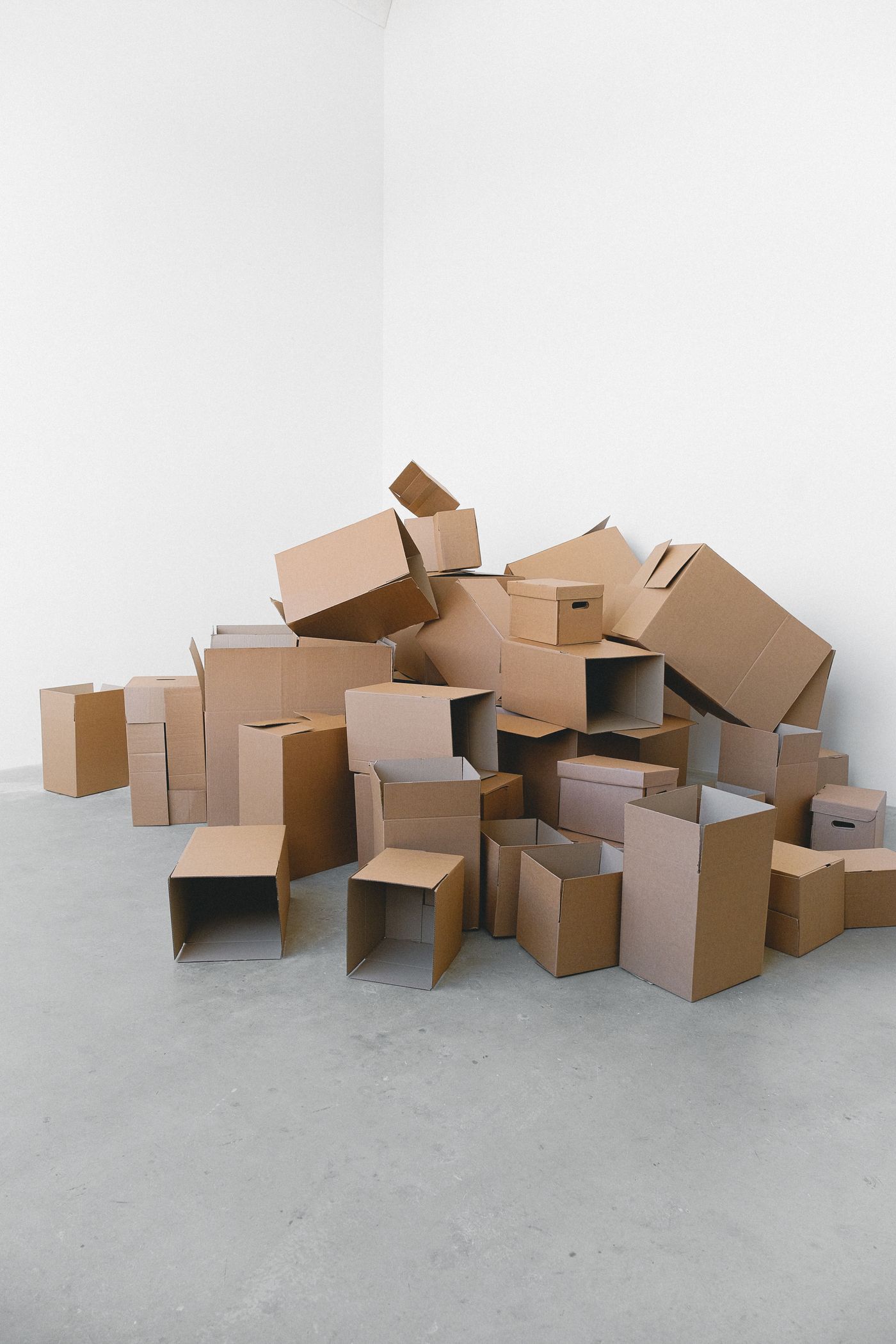 Cardboard moving boxes stacked in the corner of a room