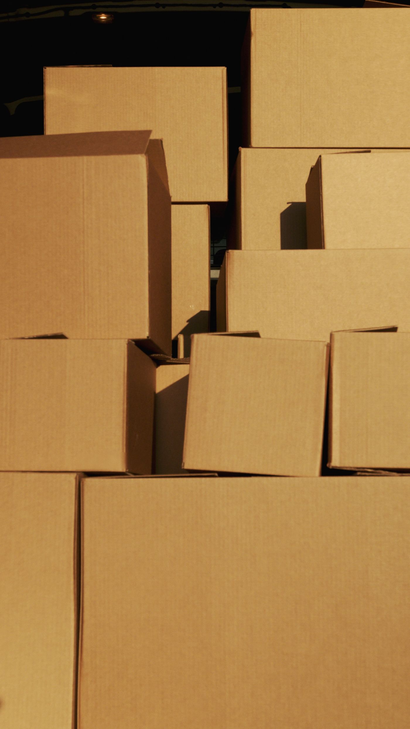 Stacked cardboard boxes lit by sunlight, ready to load