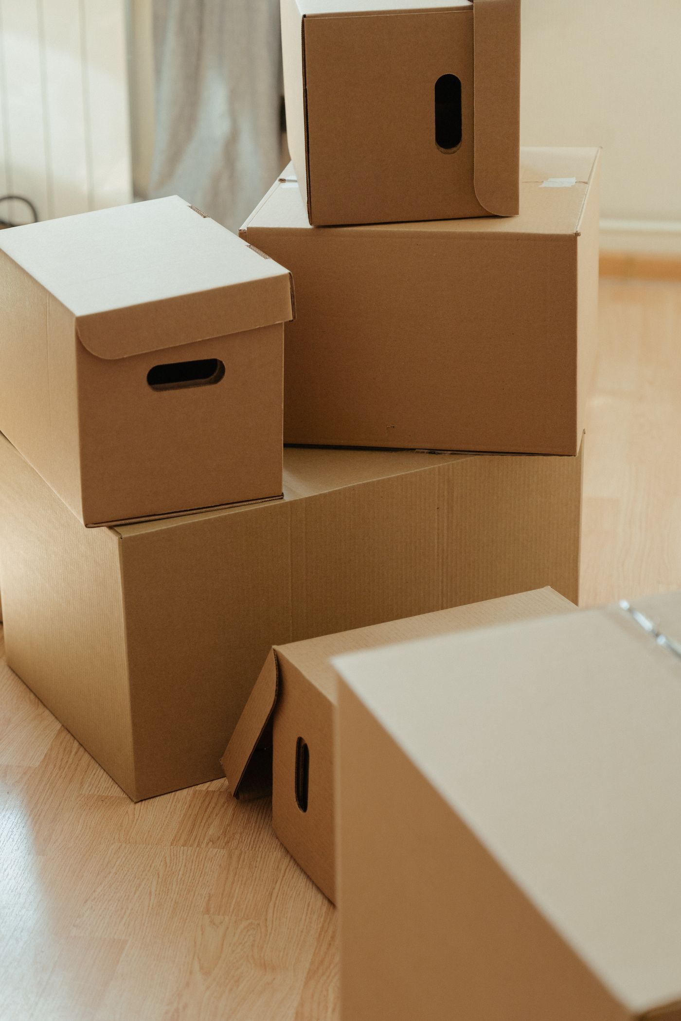 A cardboard box on a clean wood floor by a window