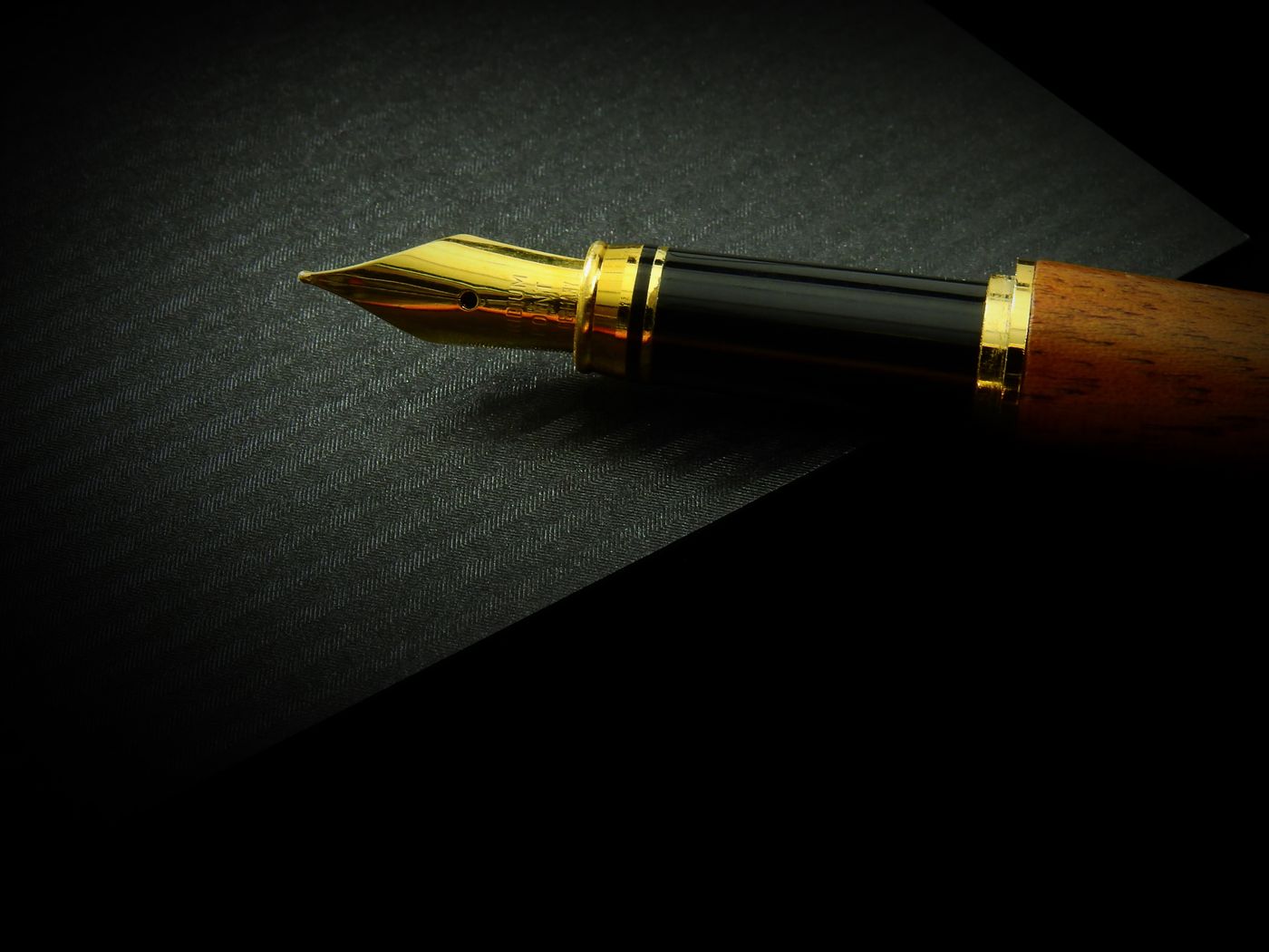 A fountain pen resting on an open notebook