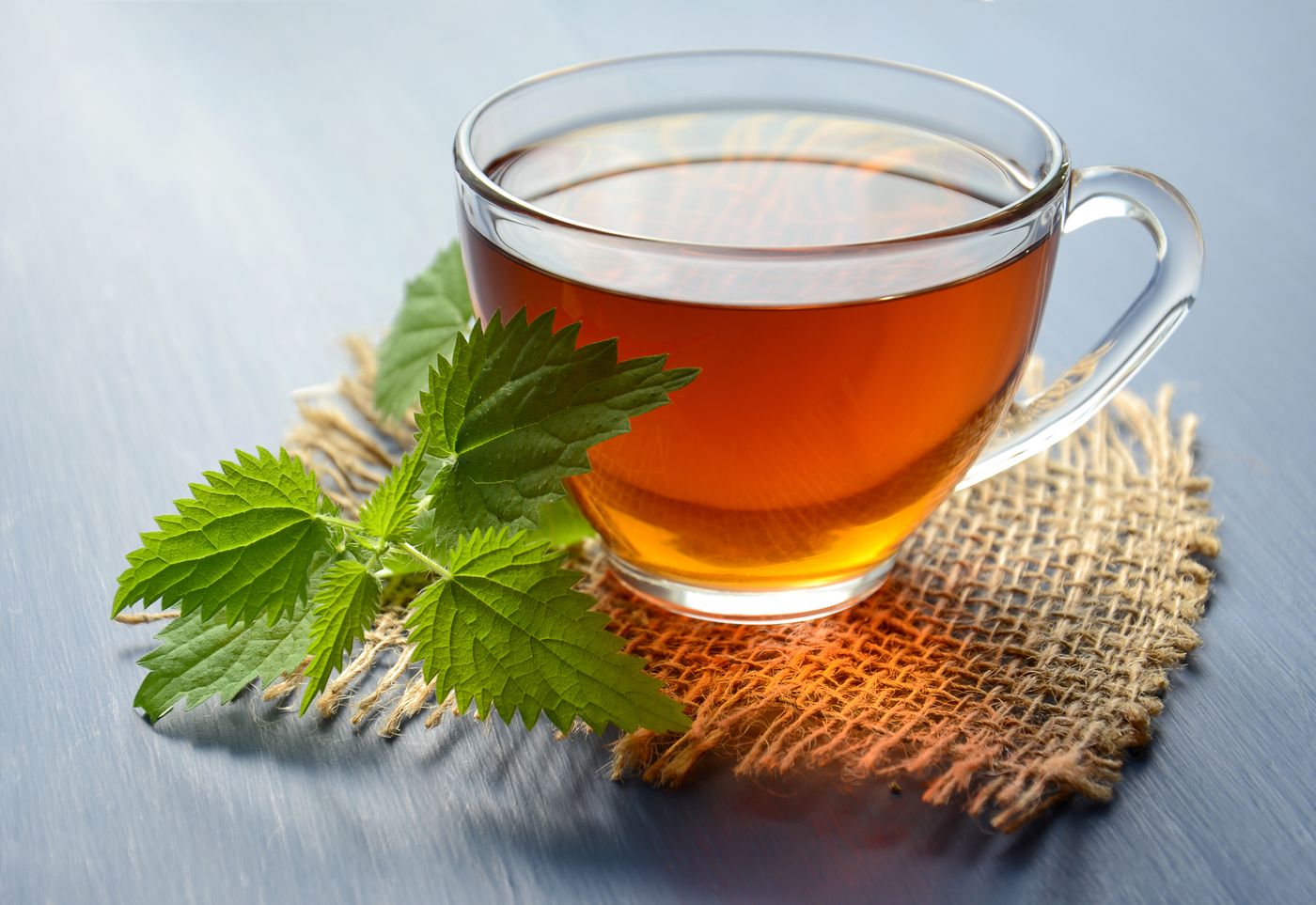 A glass cup of brewed tea on a textured surface