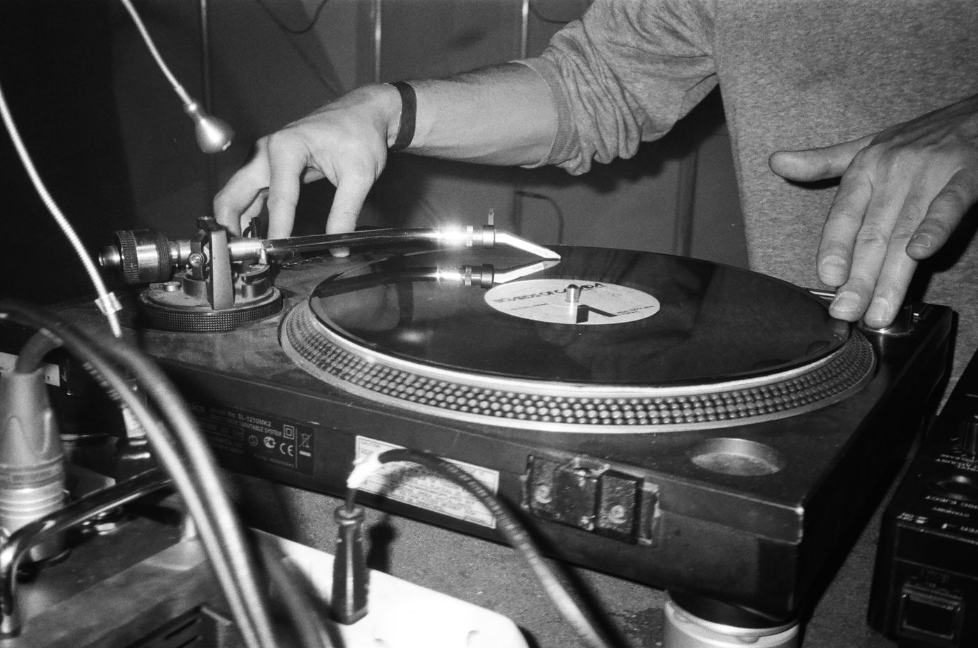 Hands cueing a record on a turntable