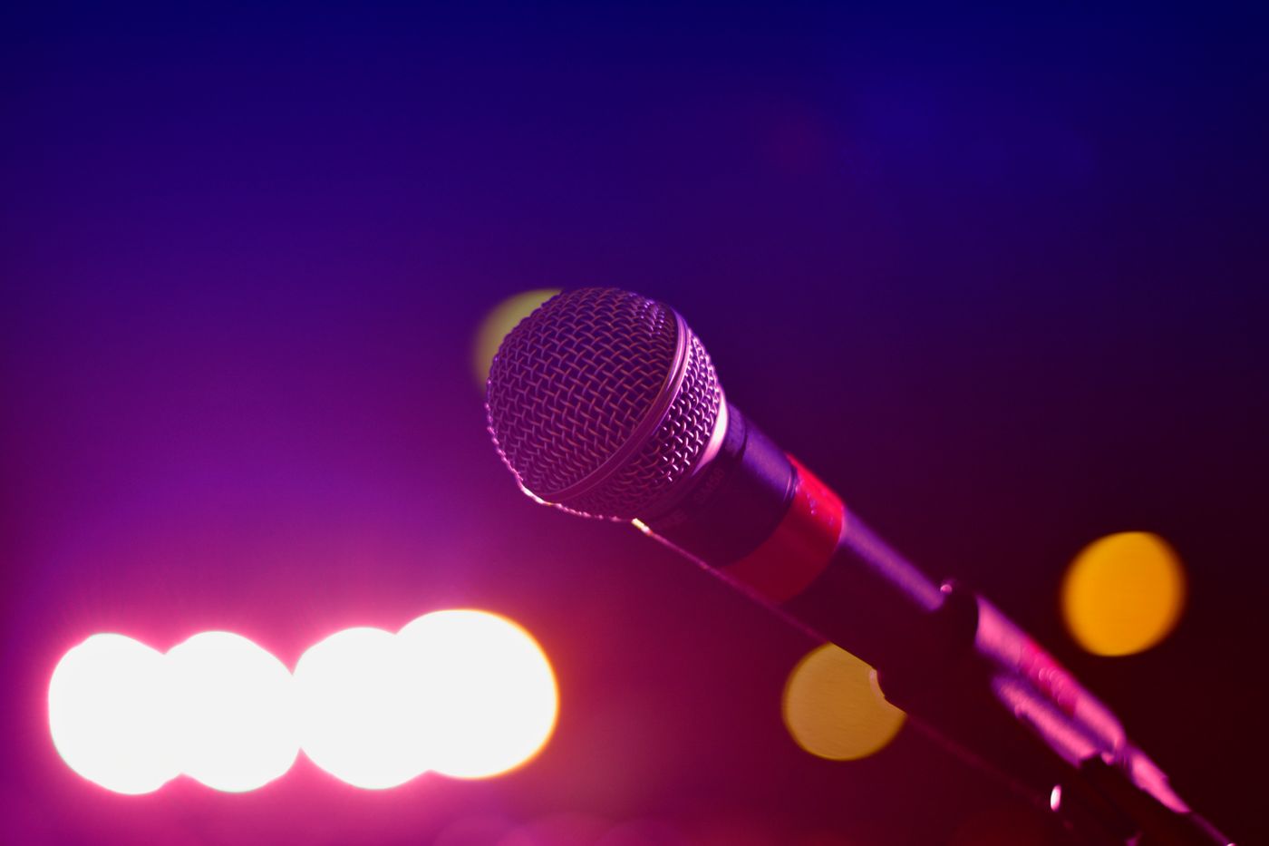 A microphone on a small stage under coloured light