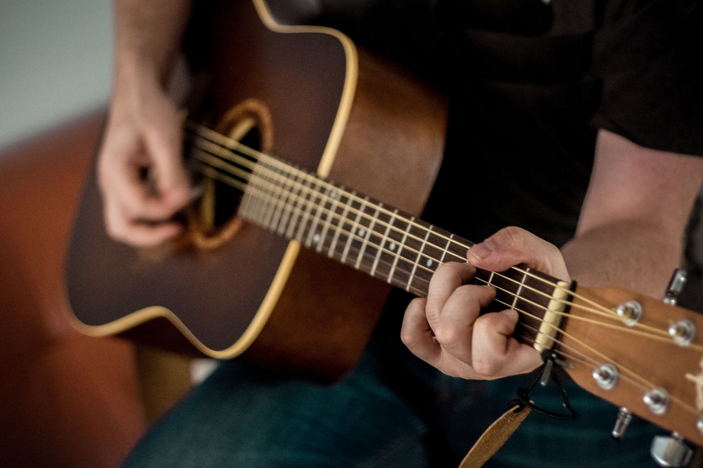 Hands playing an acoustic guitar
