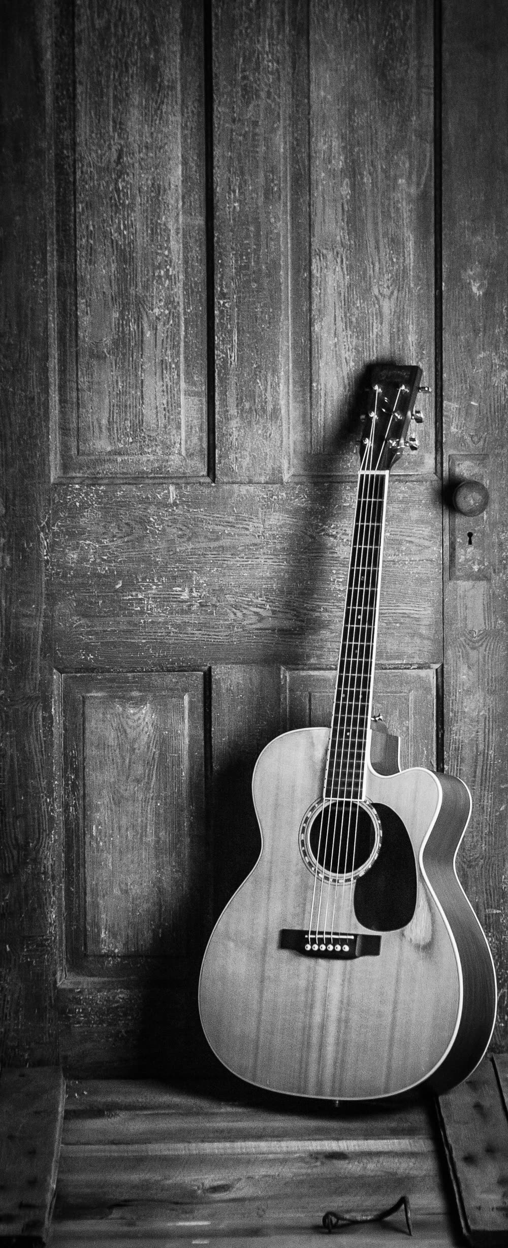 Acoustic guitar leaning against a wall
