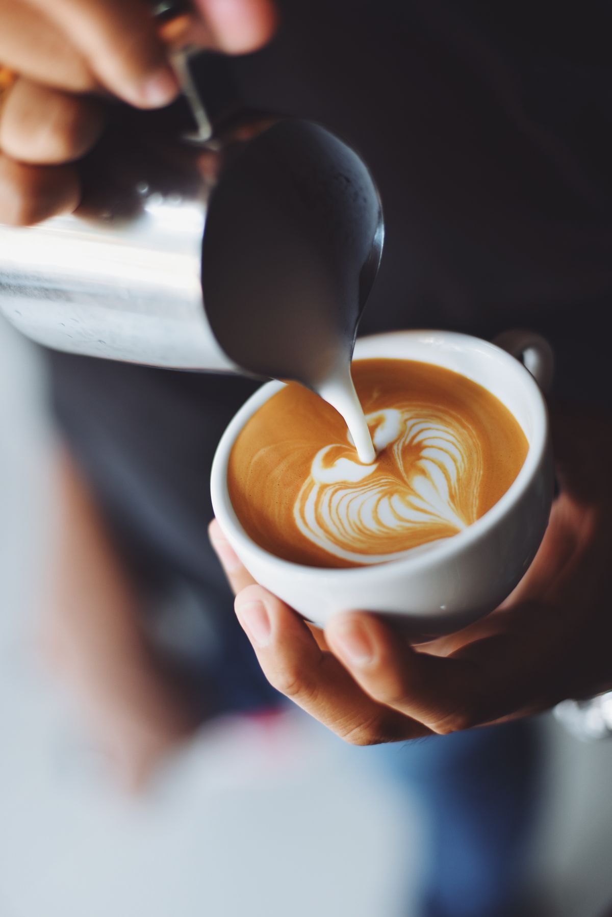 Latte with rosetta art held in both hands