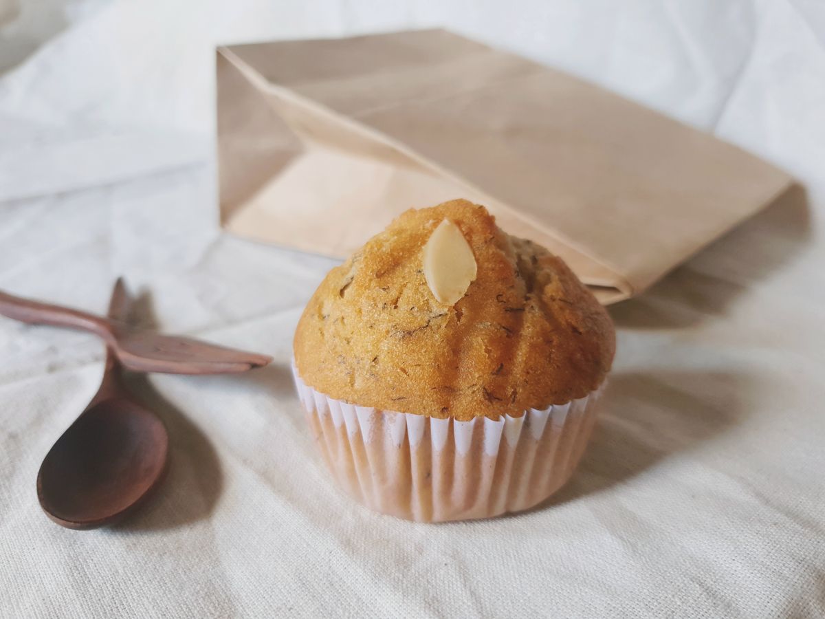 Gluten-free muffin beside a paper bag
