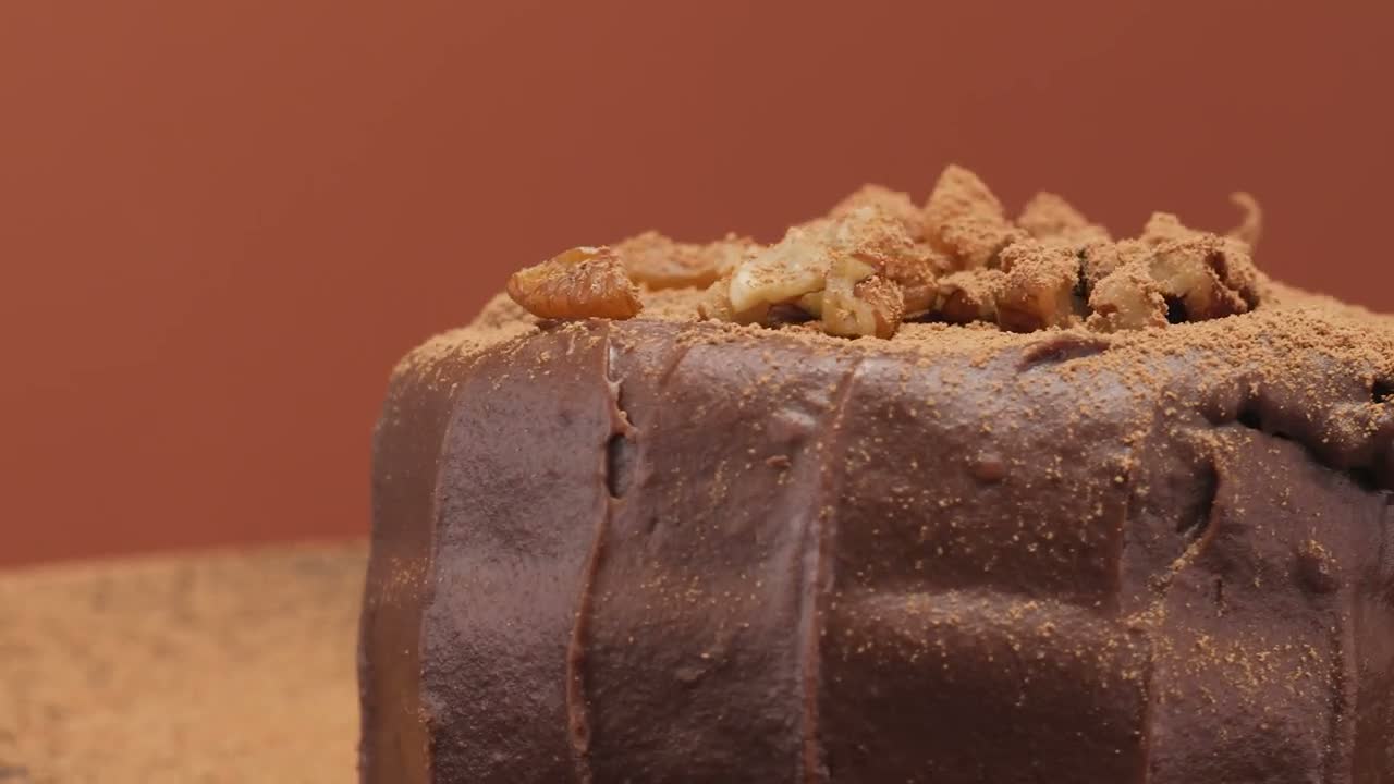 A dark chocolate cake dusted with cocoa, finished at the bench